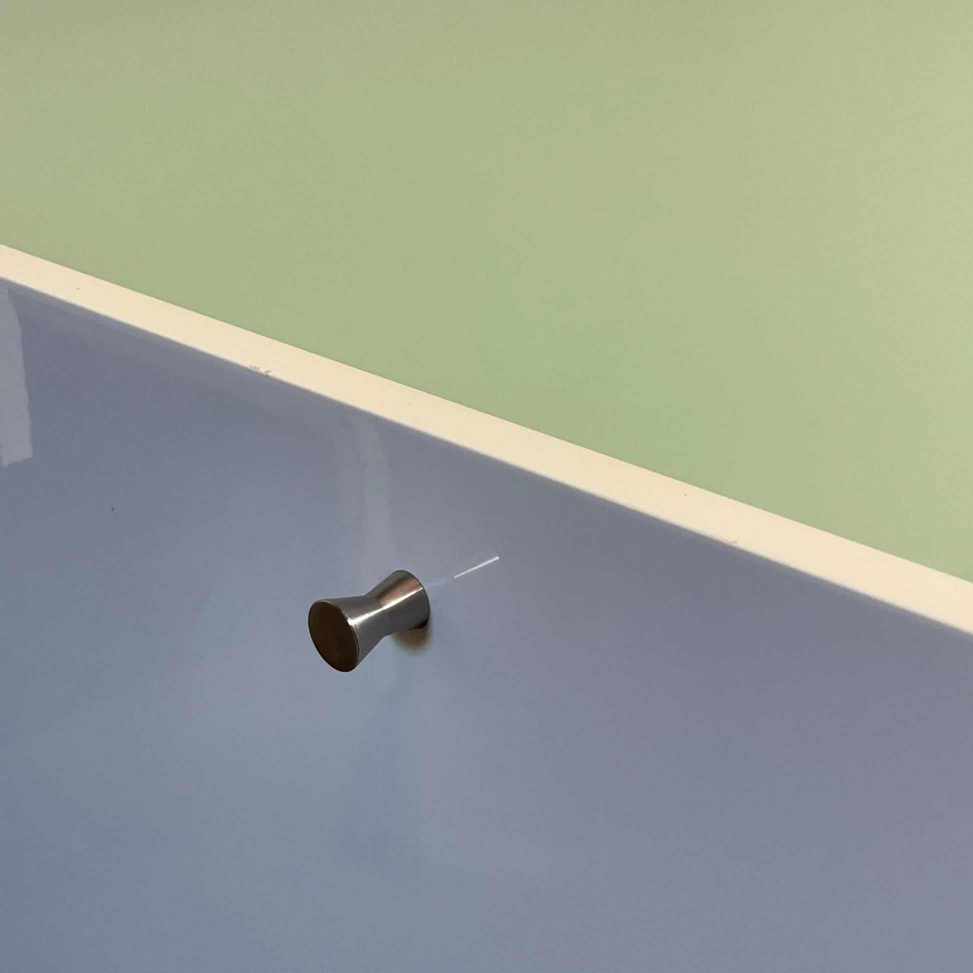 The Cassina 255-256 Flat Sideboard in glossy white lacquer features two left drawers, a spacious right compartment, and four metal legs, all by Cassina, shown against a plain background.