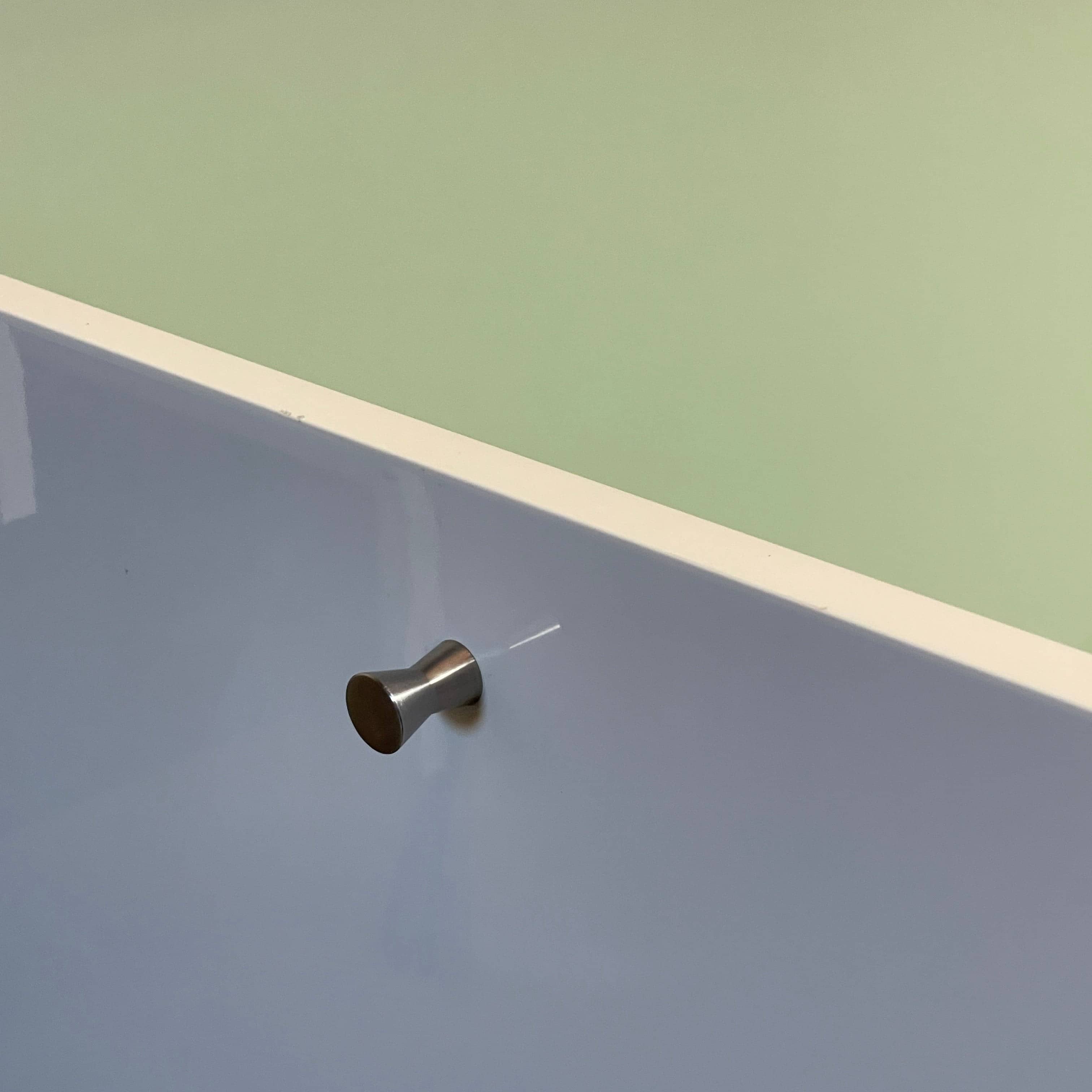 The Cassina 255-256 Flat Sideboard in glossy white lacquer features two left drawers, a spacious right compartment, and four metal legs, all by Cassina, shown against a plain background.