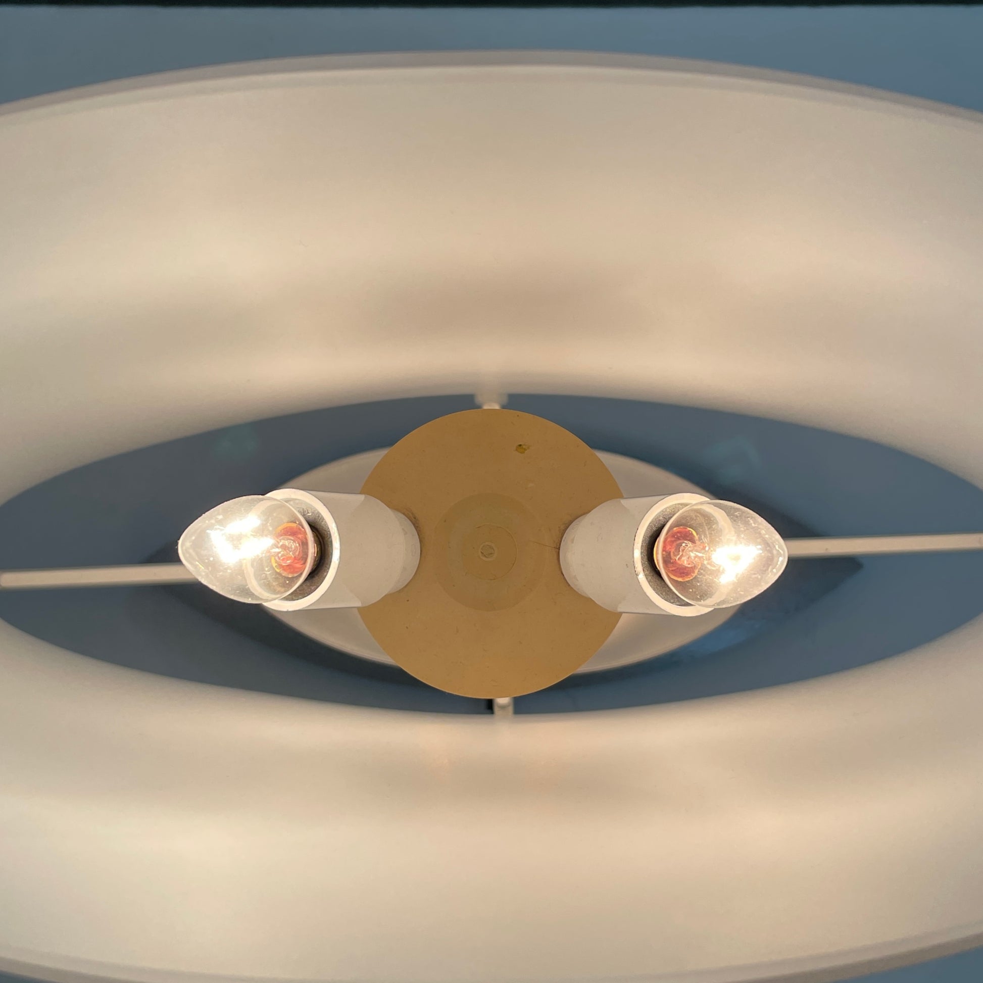 The Fontana Arte 3064 Table Light by Fontana Arte, echoing Daniela Puppa's designs, boasts a wide conical shade for a warm glow. It sits elegantly on a white surface against a plain backdrop, capturing the essence of postmodern art.