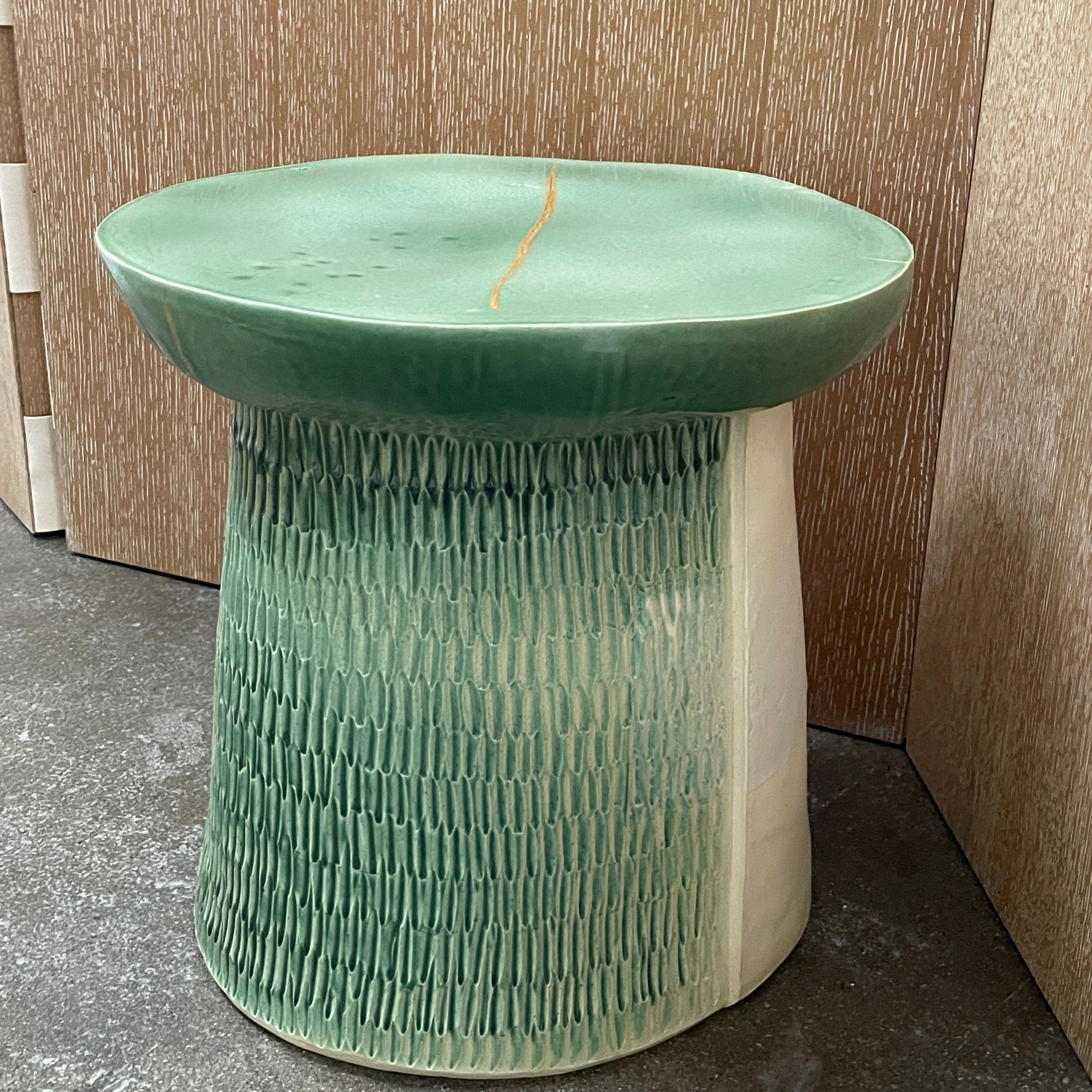 The Artist Allyn Davis Ceramic Side Table in Celadon features a textured cylindrical base and smooth round top, all on a plain white background.