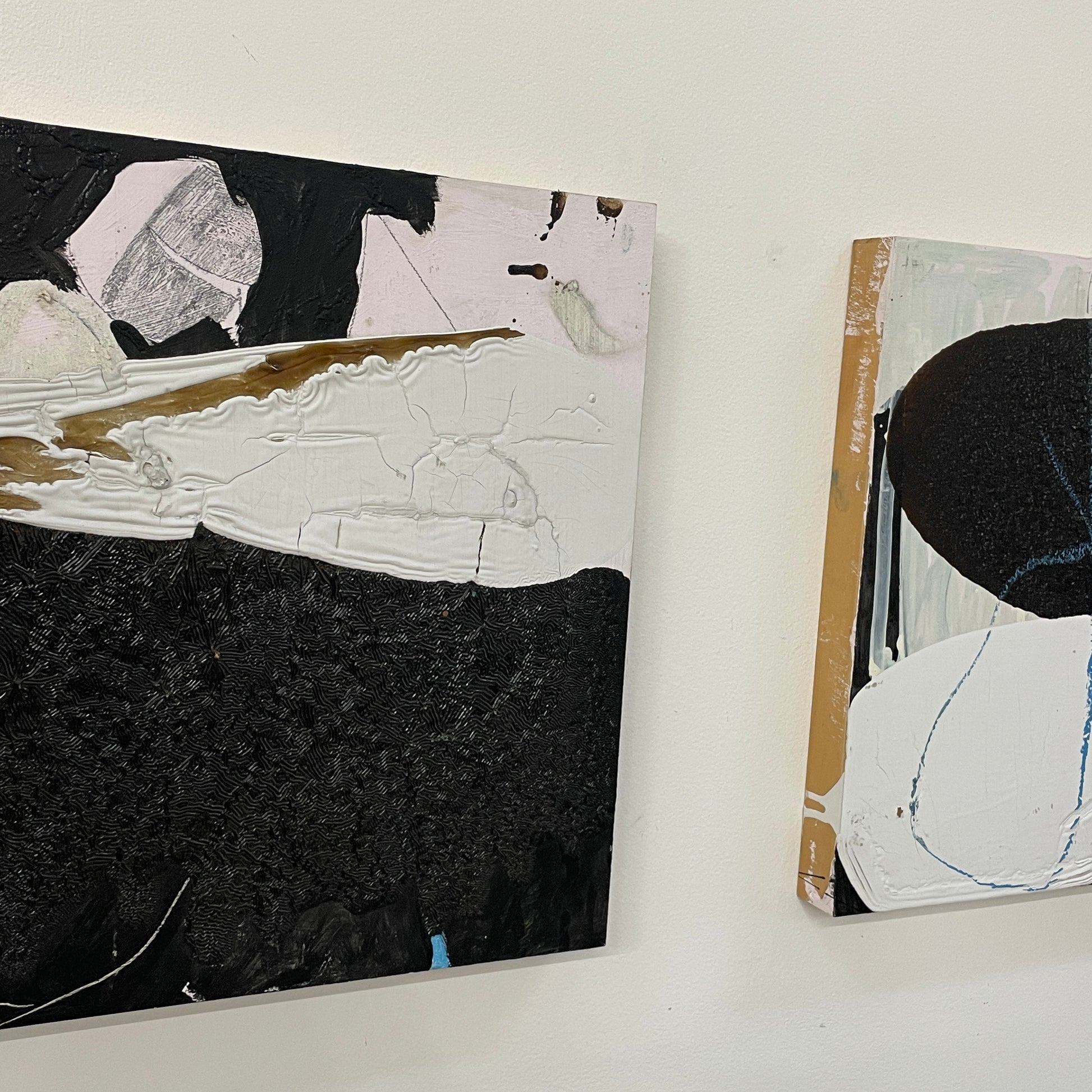 The Diptych, "Jose Is Talking To The Neighbor" by Artist, features abstract paintings with a striking interplay of black, white, and gray. The left canvas has angular shapes contrasted by more rounded forms on the right, set against a plain white background.