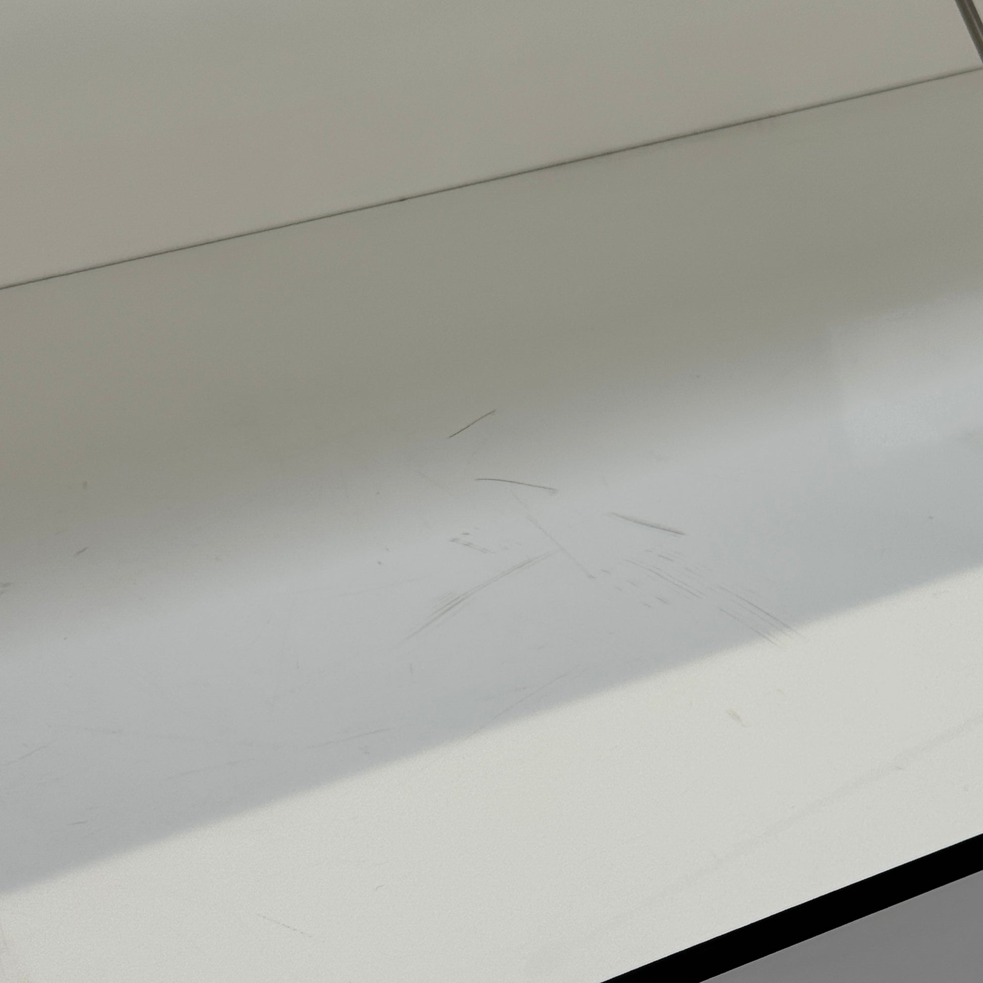 Two long, empty black shelves from the B&B Italia PAB Shelving collection are mounted on a white wall, supported by evenly spaced metal brackets.