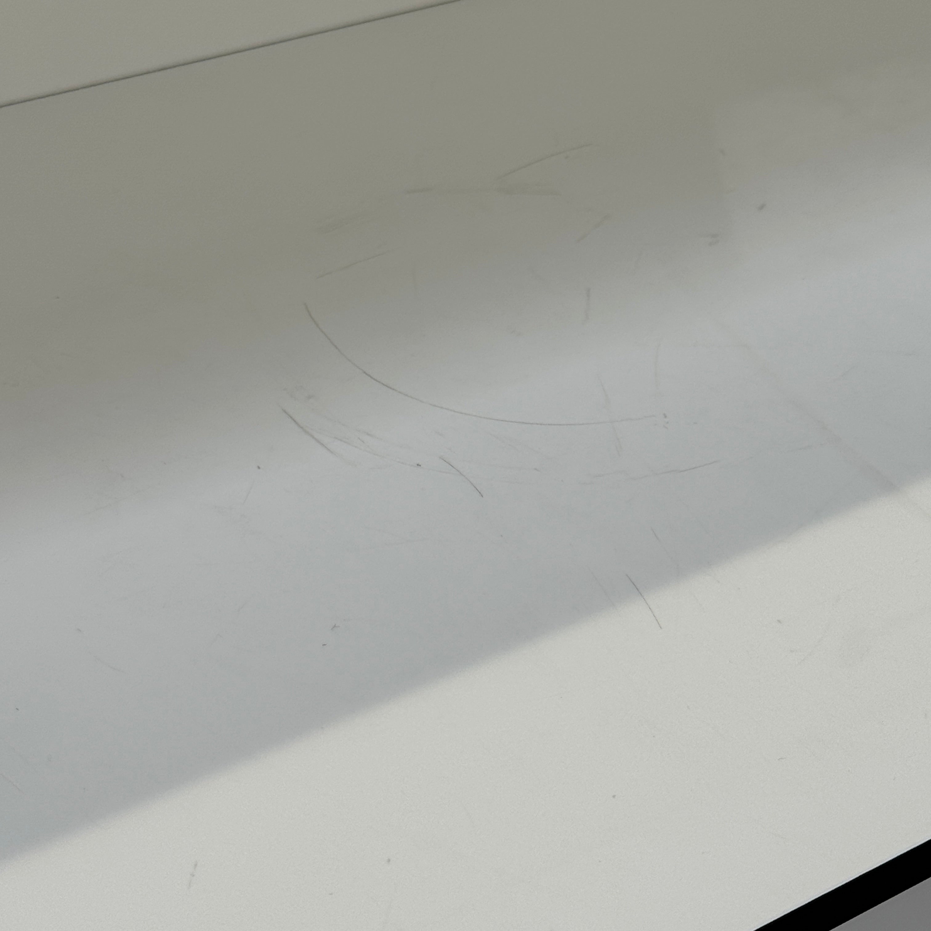 Two long, empty black shelves from the B&B Italia PAB Shelving collection are mounted on a white wall, supported by evenly spaced metal brackets.