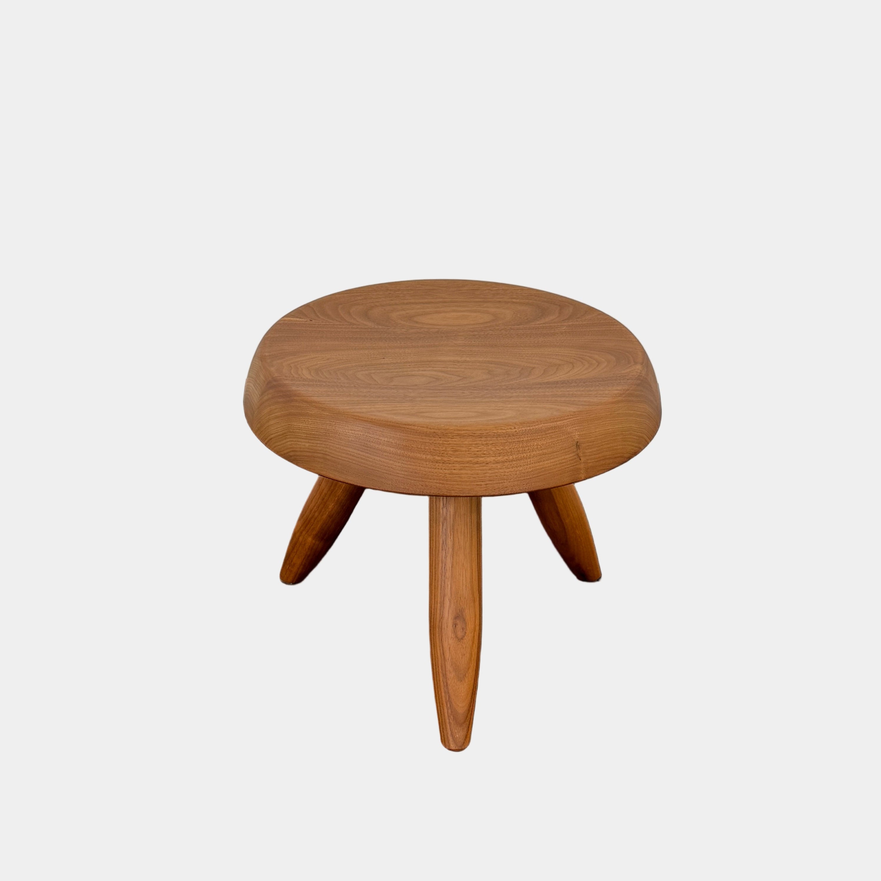 The Cassina “524 Tabouret Berger” stool by Cassina, crafted in walnut with three tapered legs and a round seat, is shown against a plain white background.