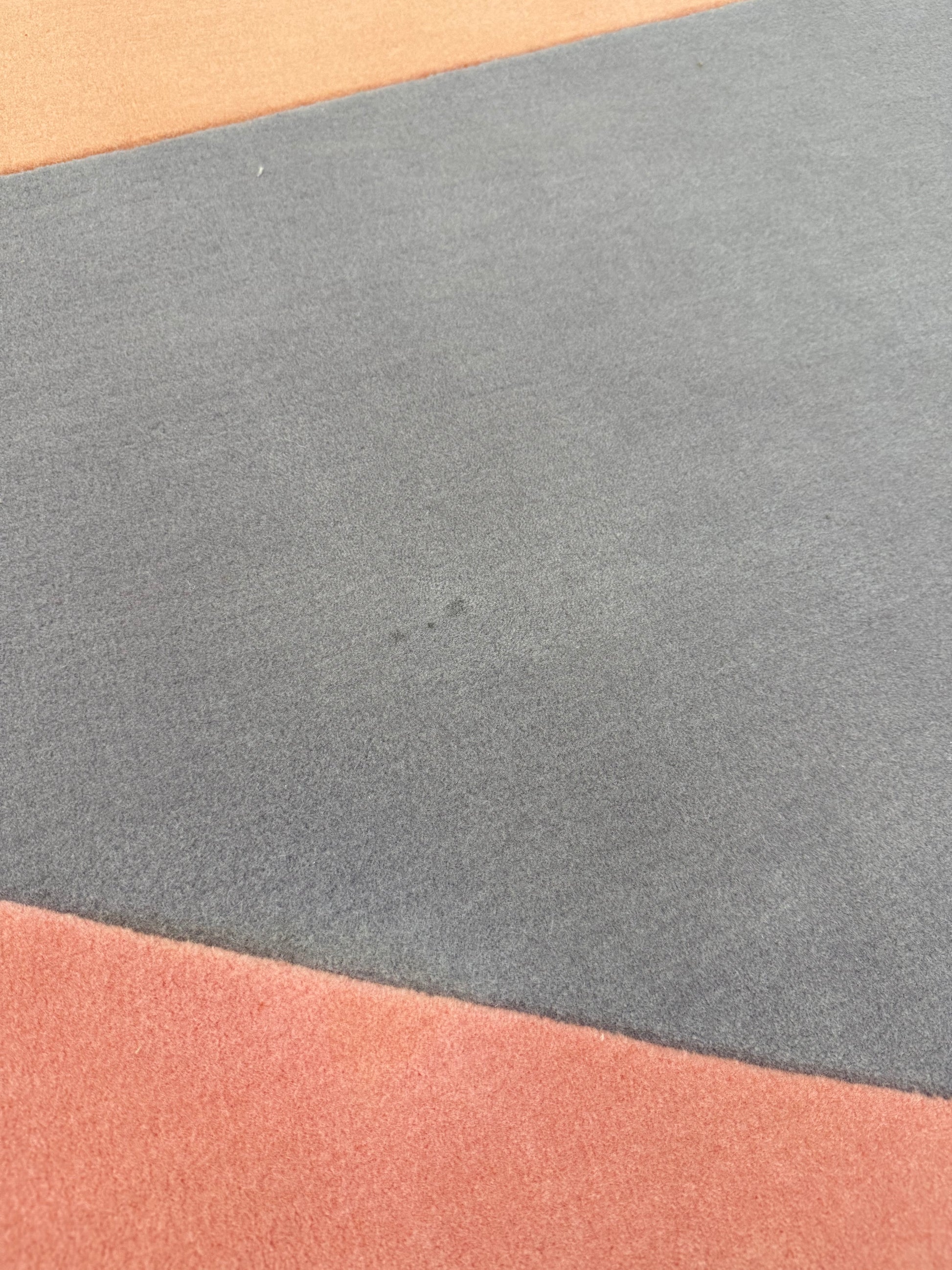 The Paul Smith Geometric Shape Split Rug Pastels features geometric designs in purple, pink, red, blue, and peach tones on a crisp white background.