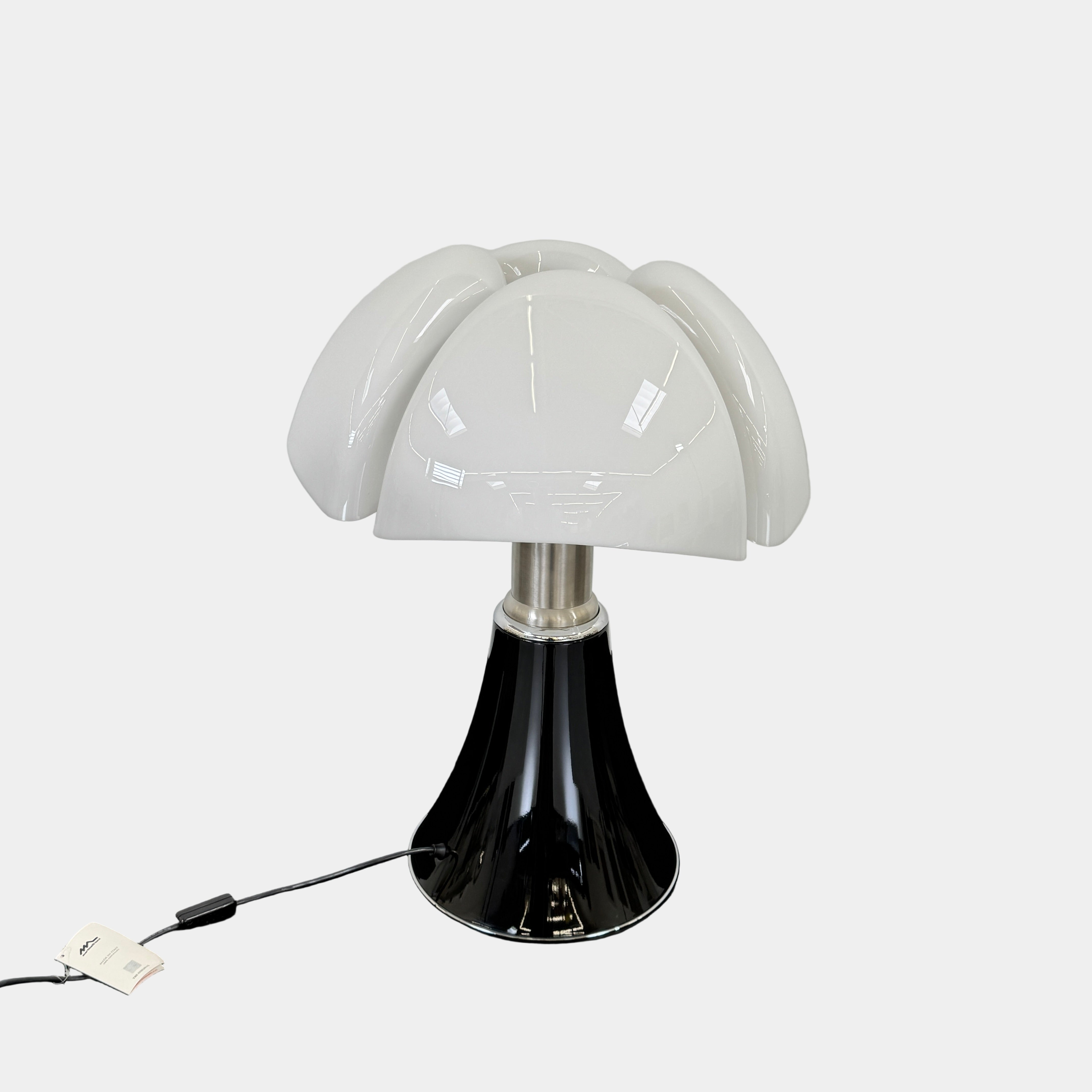 The Martinelli Luce Pipistrello Table Lamp by Martinelli Luce features a black base, silver neck, and white dome-shaped shade, shown against a plain white background with visible power cord and tag.