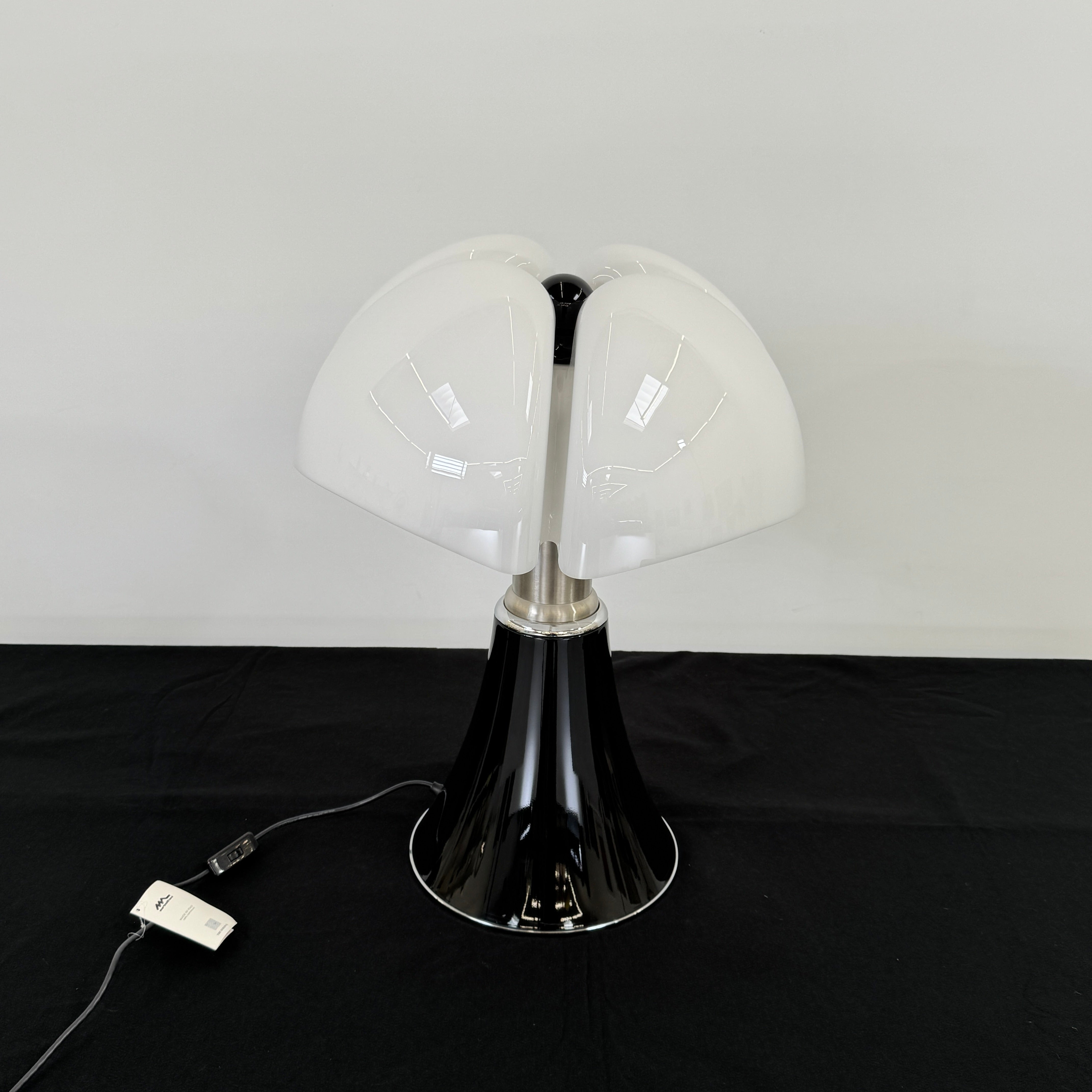 The Martinelli Luce Pipistrello Table Lamp by Martinelli Luce features a black base, silver neck, and white dome-shaped shade, shown against a plain white background with visible power cord and tag.