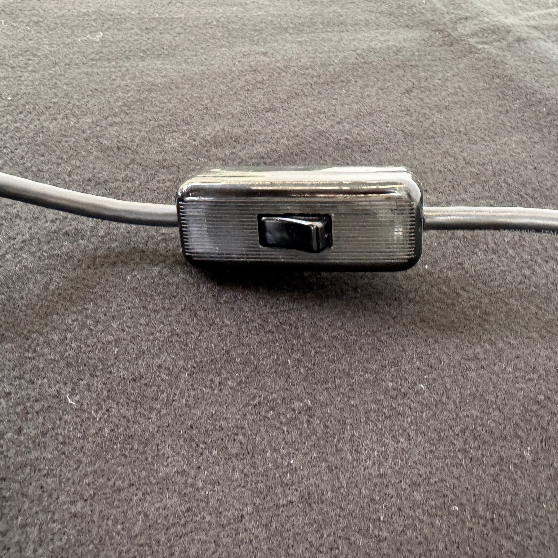 The Martinelli Luce Pipistrello Table Lamp by Martinelli Luce features a black base, silver neck, and white dome-shaped shade, shown against a plain white background with visible power cord and tag.