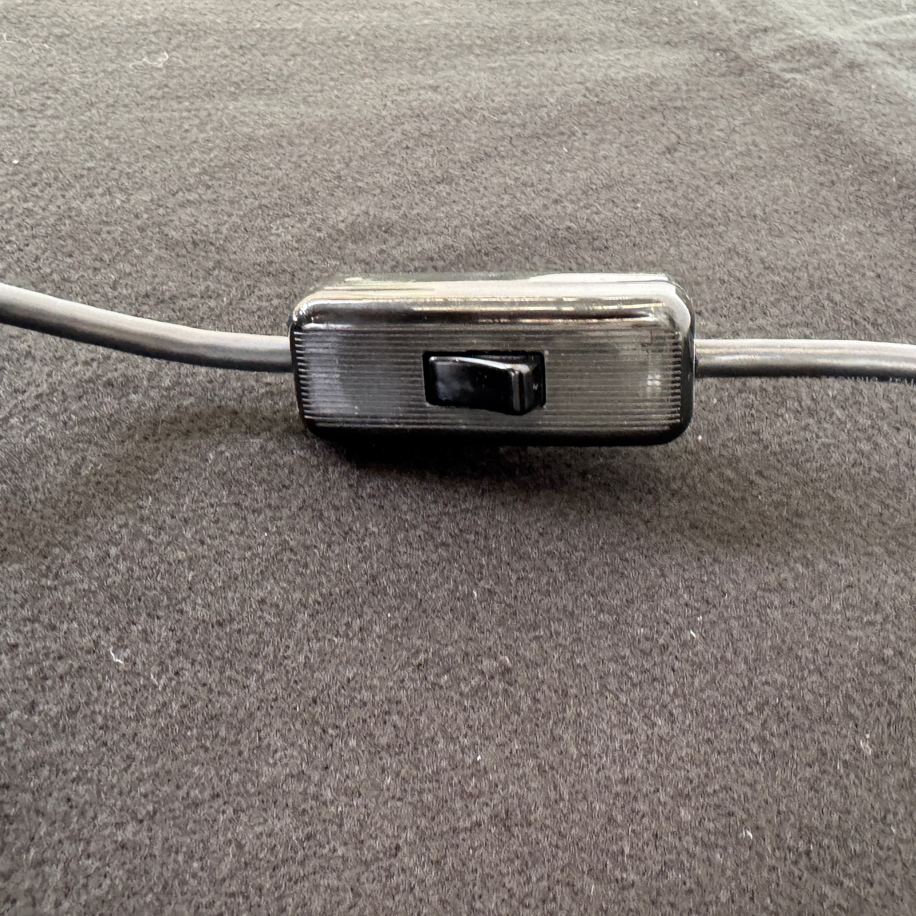 The Martinelli Luce Pipistrello Table Lamp by Martinelli Luce features a black base, silver neck, and white dome-shaped shade, shown against a plain white background with visible power cord and tag.