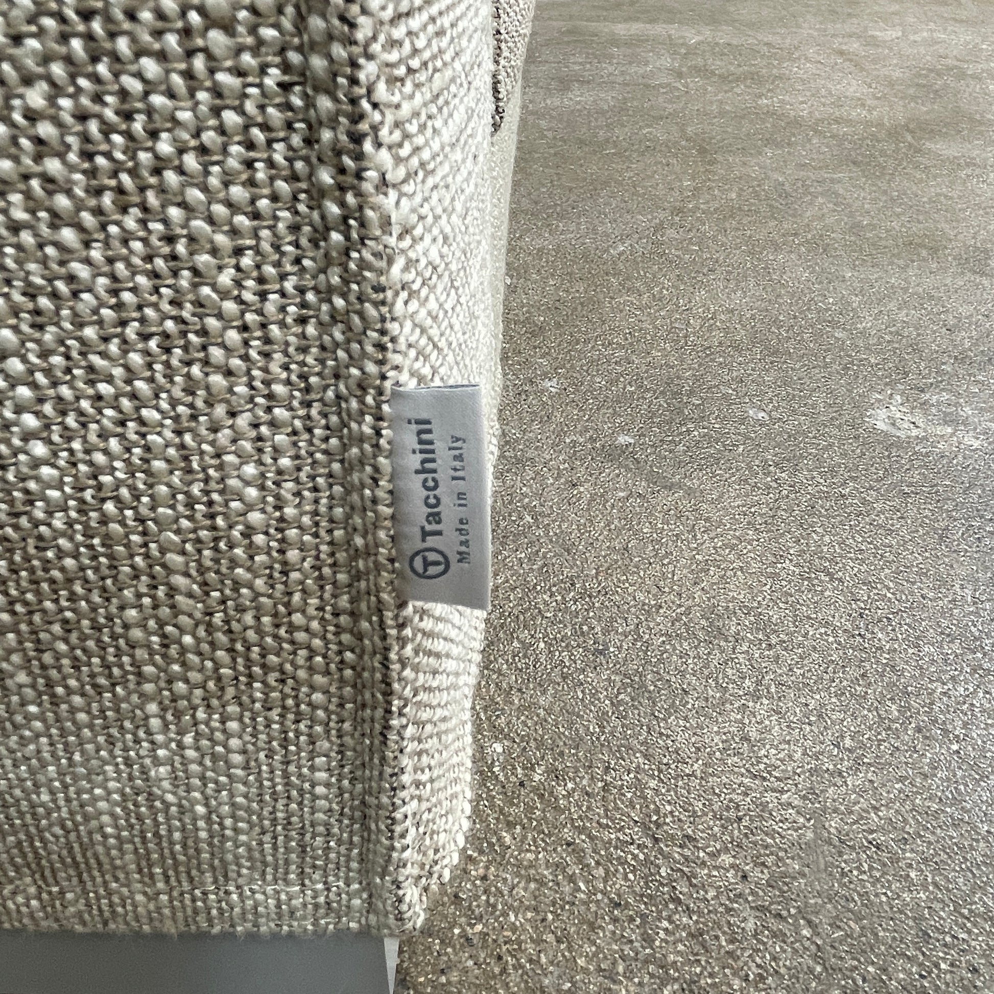 The Tacchini Low Sofa with Convertible Backrest by Tacchini showcases a sleek gray design, clean lines, and rectangular arms, all elegantly set against a crisp white background.