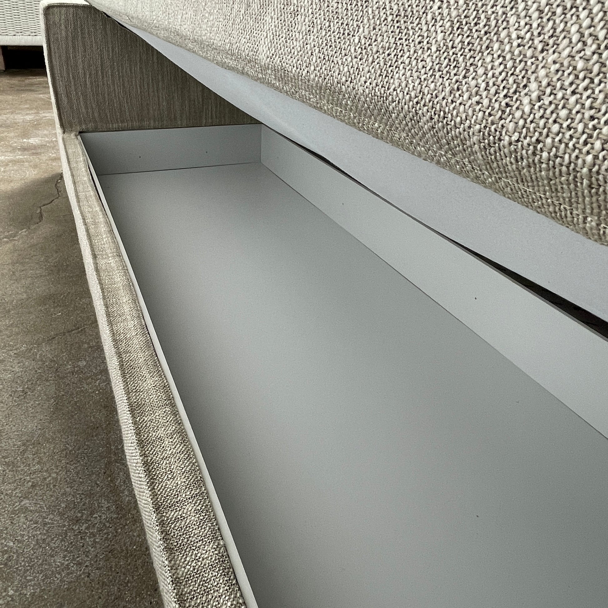 The Tacchini Low Sofa with Convertible Backrest by Tacchini showcases a sleek gray design, clean lines, and rectangular arms, all elegantly set against a crisp white background.