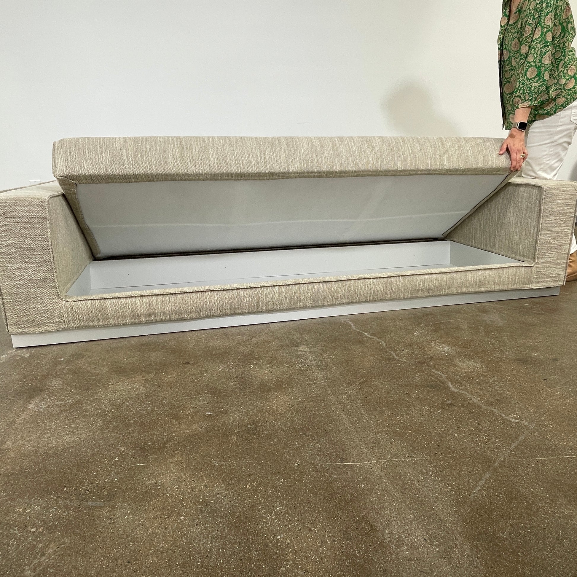 The Tacchini Low Sofa with Convertible Backrest by Tacchini showcases a sleek gray design, clean lines, and rectangular arms, all elegantly set against a crisp white background.