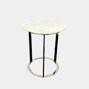 The B&B Italia Mera Accent Table features a round Carrara marble top and a three-legged metal frame with a circular base, showcasing B&B Italia's signature elegance.