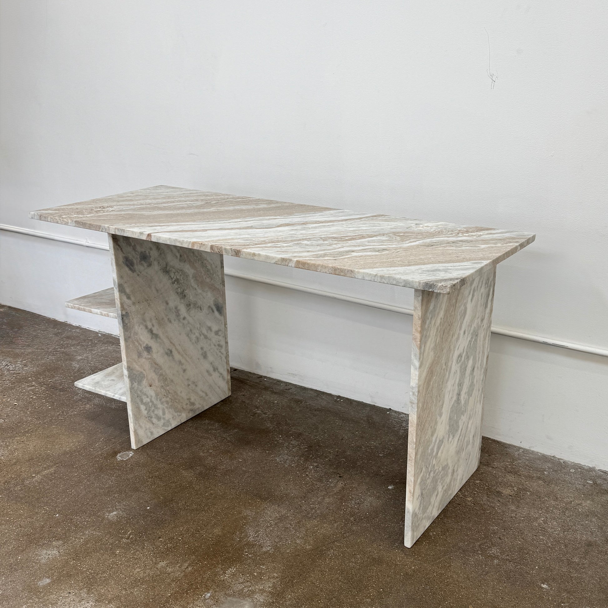 The CB2 Hera Torrento Brown Marble Desk with Shelves features two side panels and two open left corner shelves, showcasing a light gray and beige pattern inspired by Torrento brown marble.