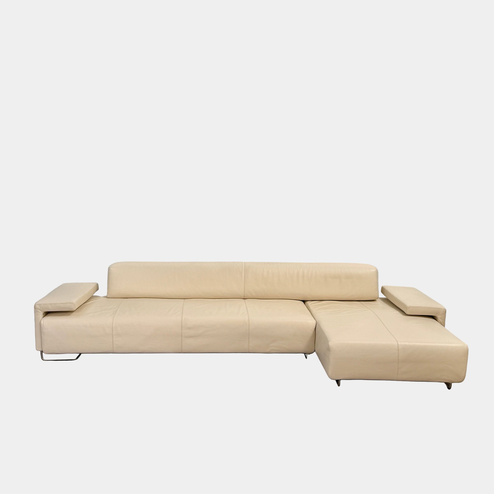 The Moroso Lowland Sectional Sofa by Moroso features beige leather, a low backrest, wide armrests, and a right-side chaise lounge inspired by Patricia Urquiola’s modern design, set against a plain white background.