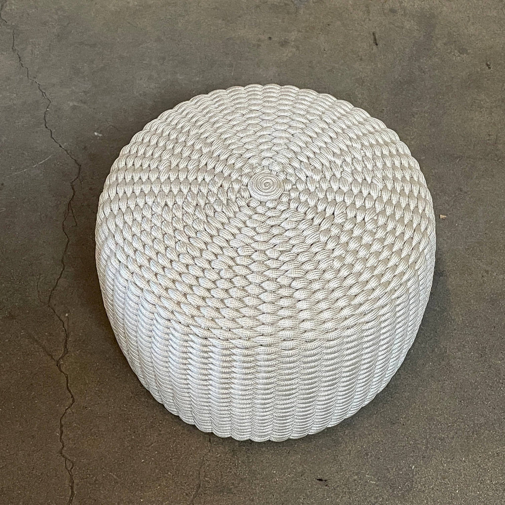 A Paola Lenti Nido ottoman, designed for outdoor seating, is showcased against a white background.