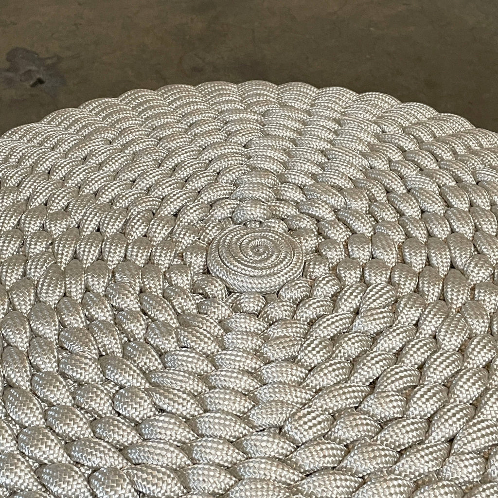 A Paola Lenti Nido ottoman, designed for outdoor seating, is showcased against a white background.