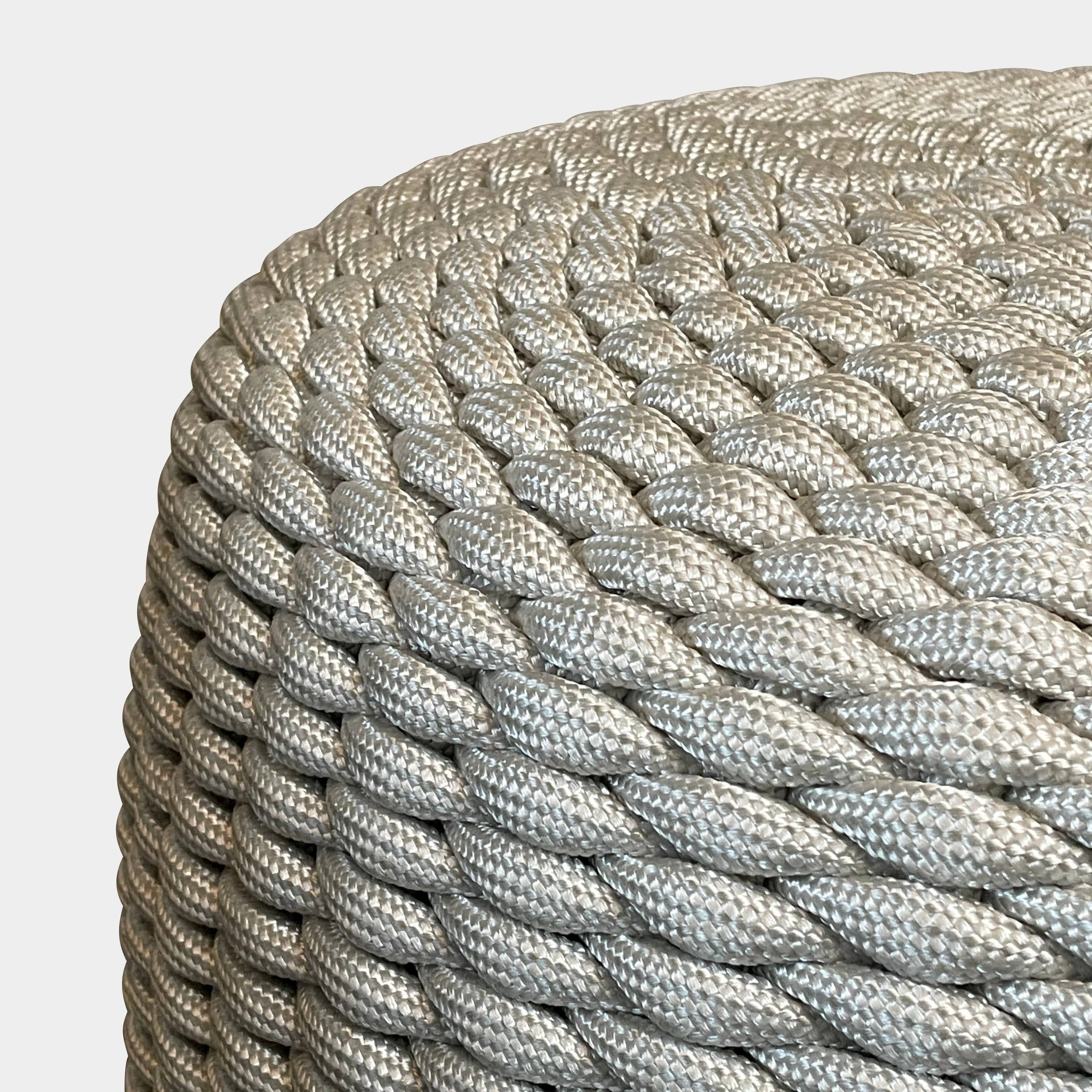 A Paola Lenti Nido ottoman, designed for outdoor seating, is showcased against a white background.