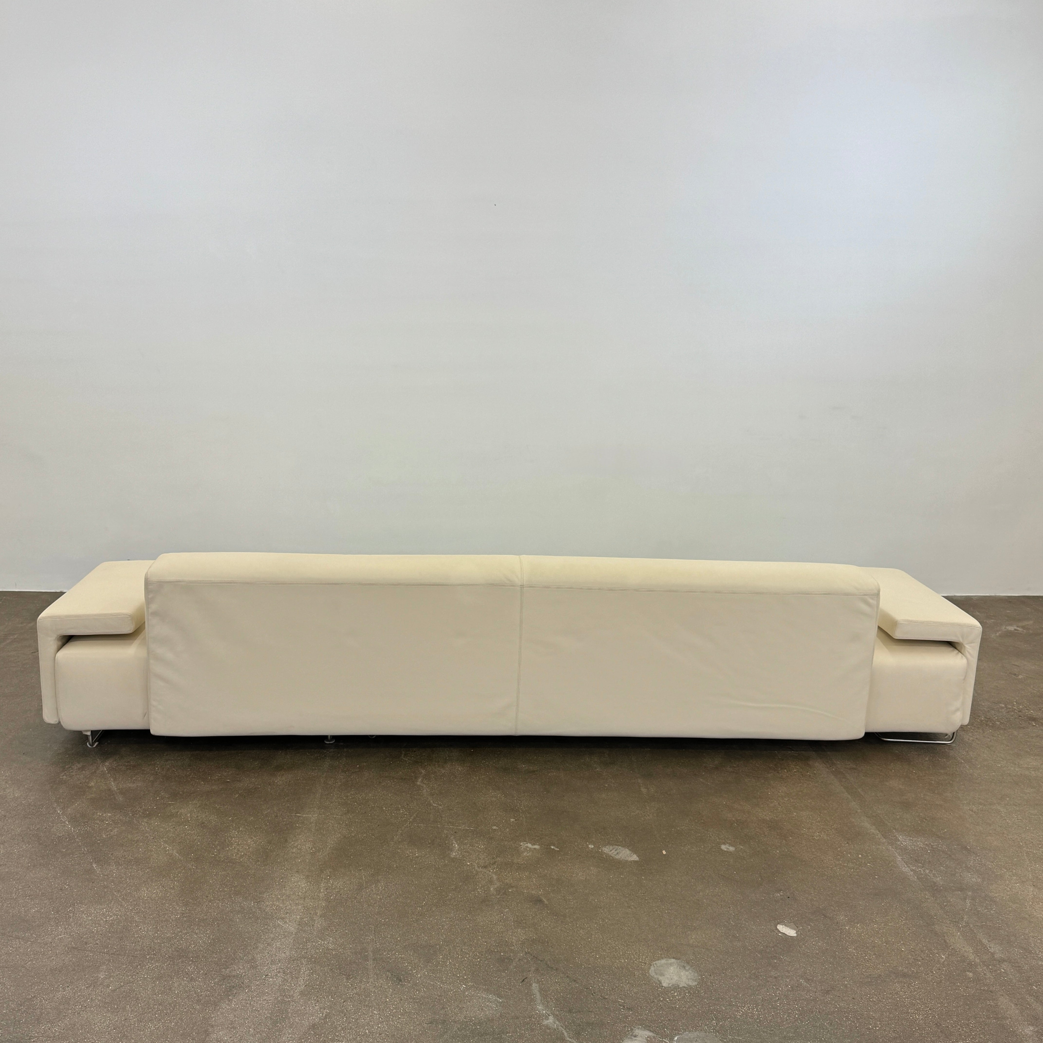 The Moroso Lowland Sectional Sofa by Moroso features beige leather, a low backrest, wide armrests, and a right-side chaise lounge inspired by Patricia Urquiola’s modern design, set against a plain white background.