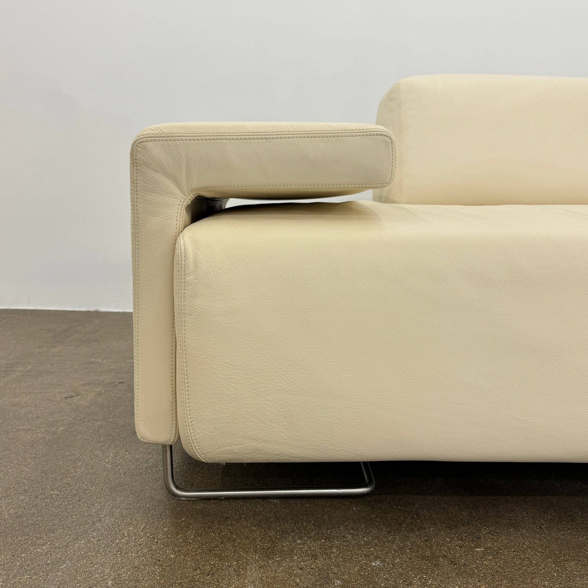 The Moroso Lowland Sectional Sofa by Moroso features beige leather, a low backrest, wide armrests, and a right-side chaise lounge inspired by Patricia Urquiola’s modern design, set against a plain white background.