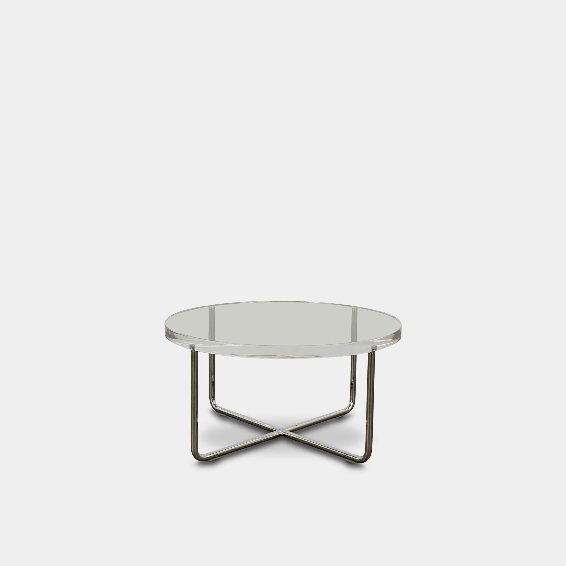 The Minotti Lucite Accent Table boasts a round glass top with a chrome metal frame and crossed base, capturing the Italian elegance synonymous with Minotti's design.