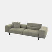 A modern Cassina Scighera Sofa by Cassina, in light gray with two matching square cushions, is placed on a bare concrete floor against a plain white wall.