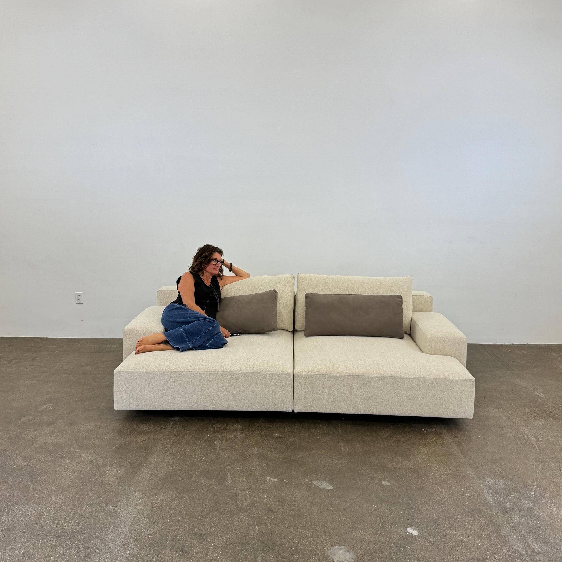 The Molteni & C Marteen Sofa is a modern beige sofa with wide armrests and two rectangular brown back cushions, featuring linen blend upholstery. Shown from the front on a white background.