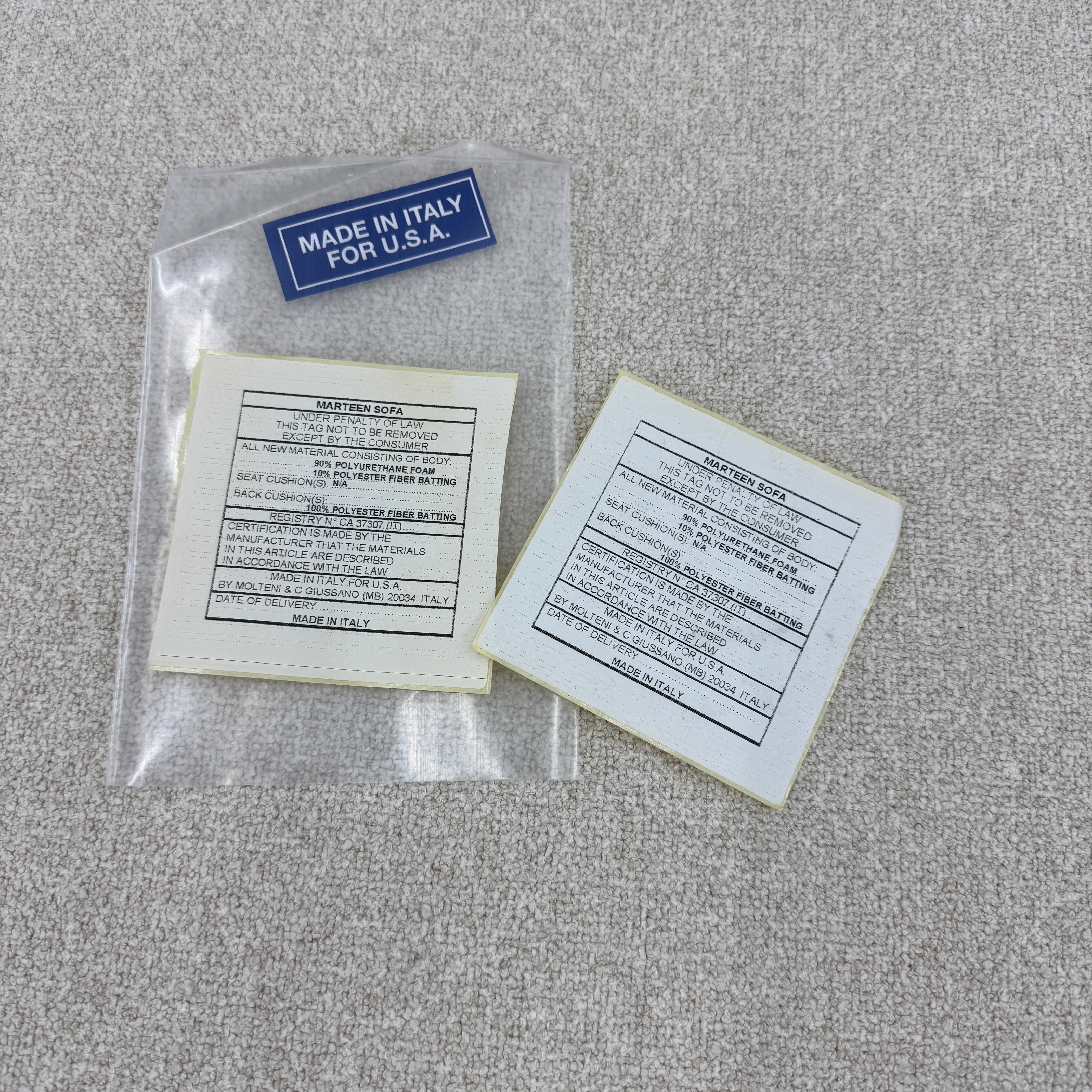 The Molteni & C Marteen Sofa is a modern beige sofa with wide armrests and two rectangular brown back cushions, featuring linen blend upholstery. Shown from the front on a white background.