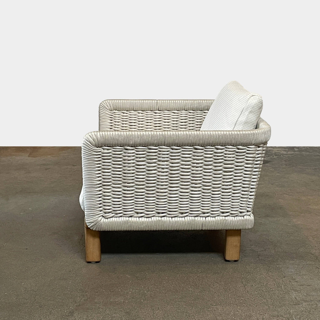 The Paola Lenti Sabi Outdoor Lounge Chair by Paola Lenti features a wicker design and includes a white cushion. It is showcased against a white background.