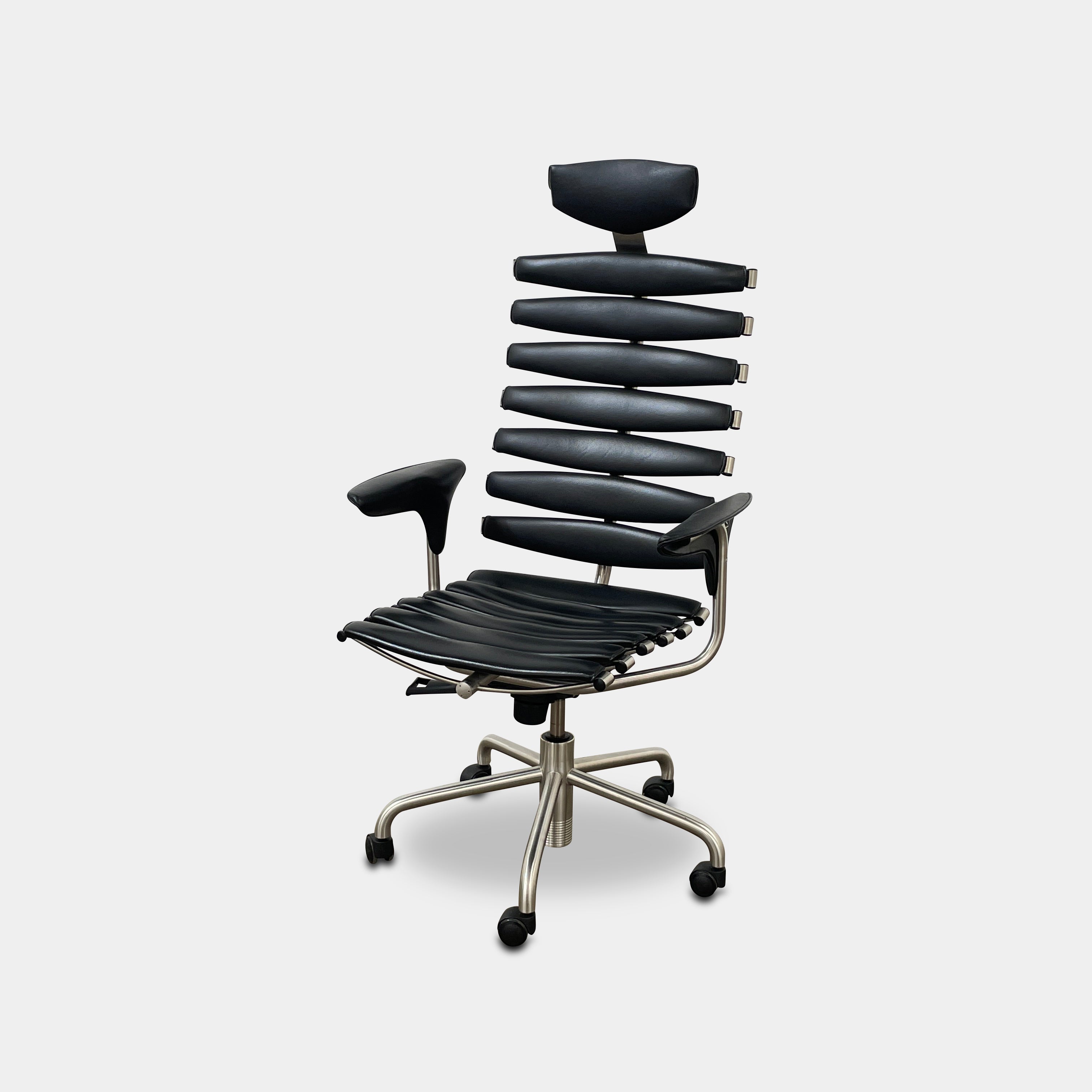 The De Sede DS-2100 High-Backed Executive Office Chair features a segmented black leather backrest, adjustable armrests, headrest, and a sturdy metal swivel base with five caster wheels.