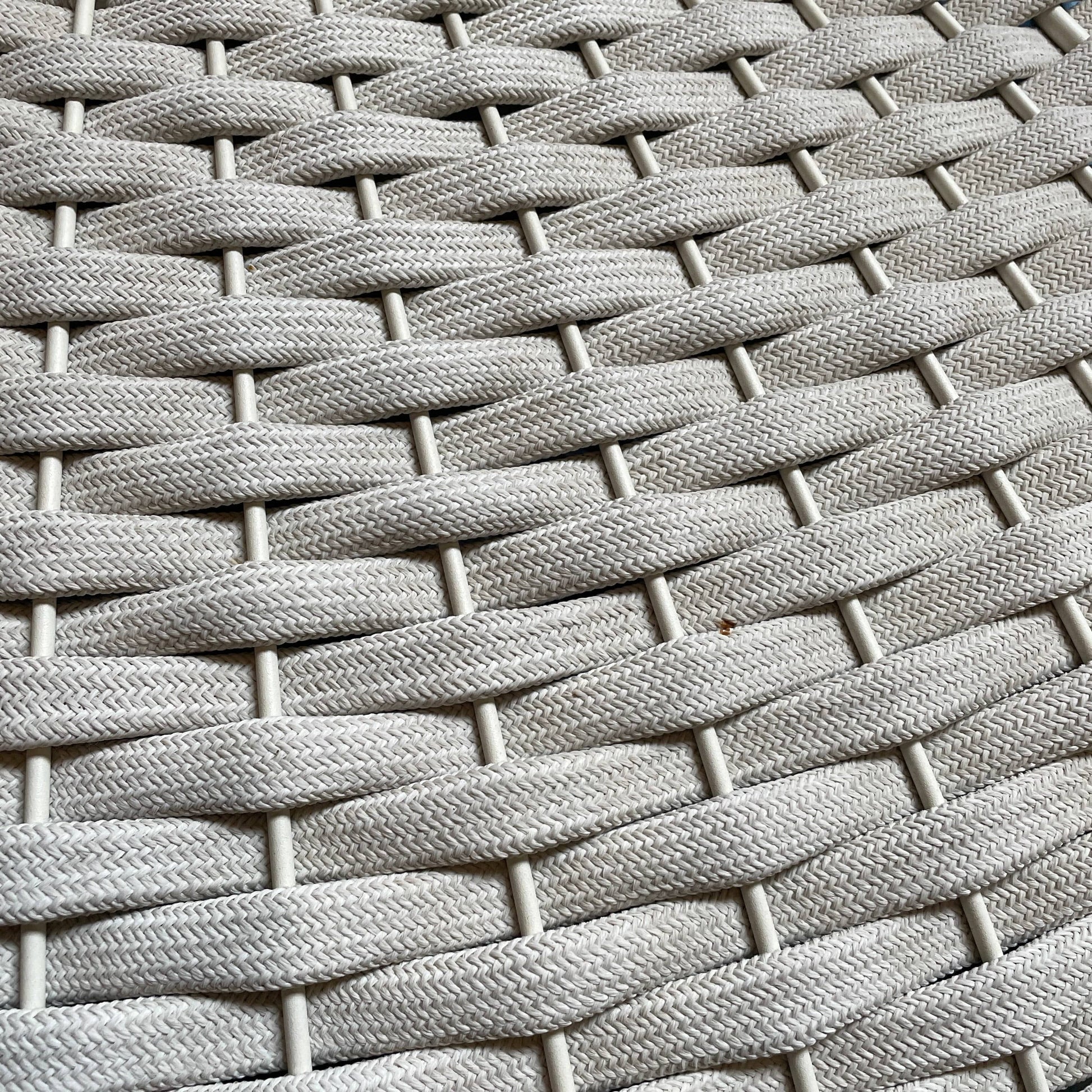 A Paola Lenti Mogambo Parasol on a white stand, designed by Paola Lenti.