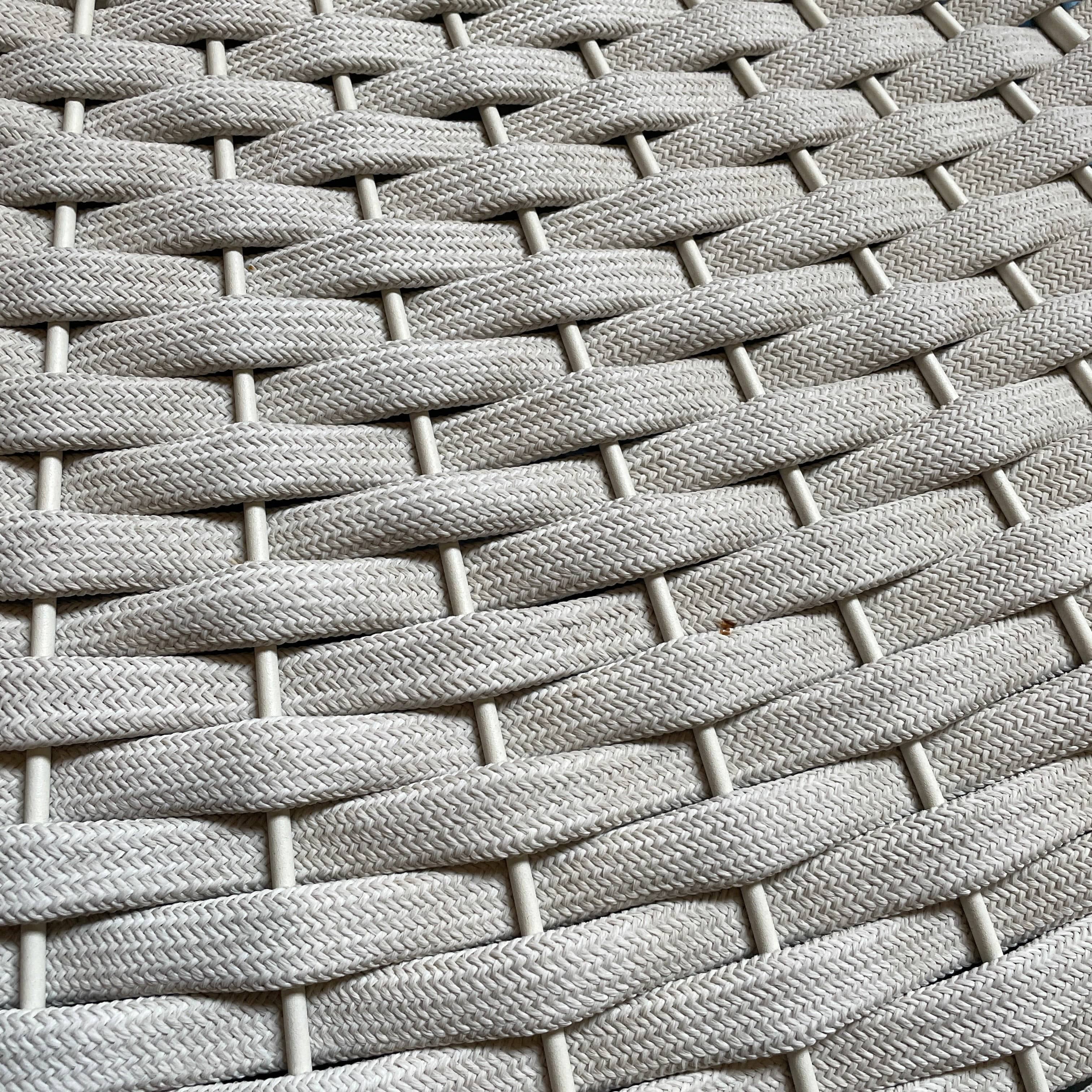 A Paola Lenti Mogambo Parasol on a white stand, designed by Paola Lenti.