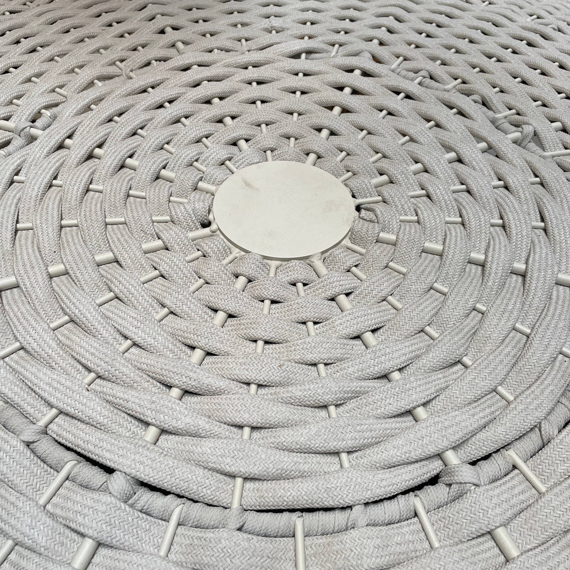 A Paola Lenti Mogambo Parasol on a white stand, designed by Paola Lenti.