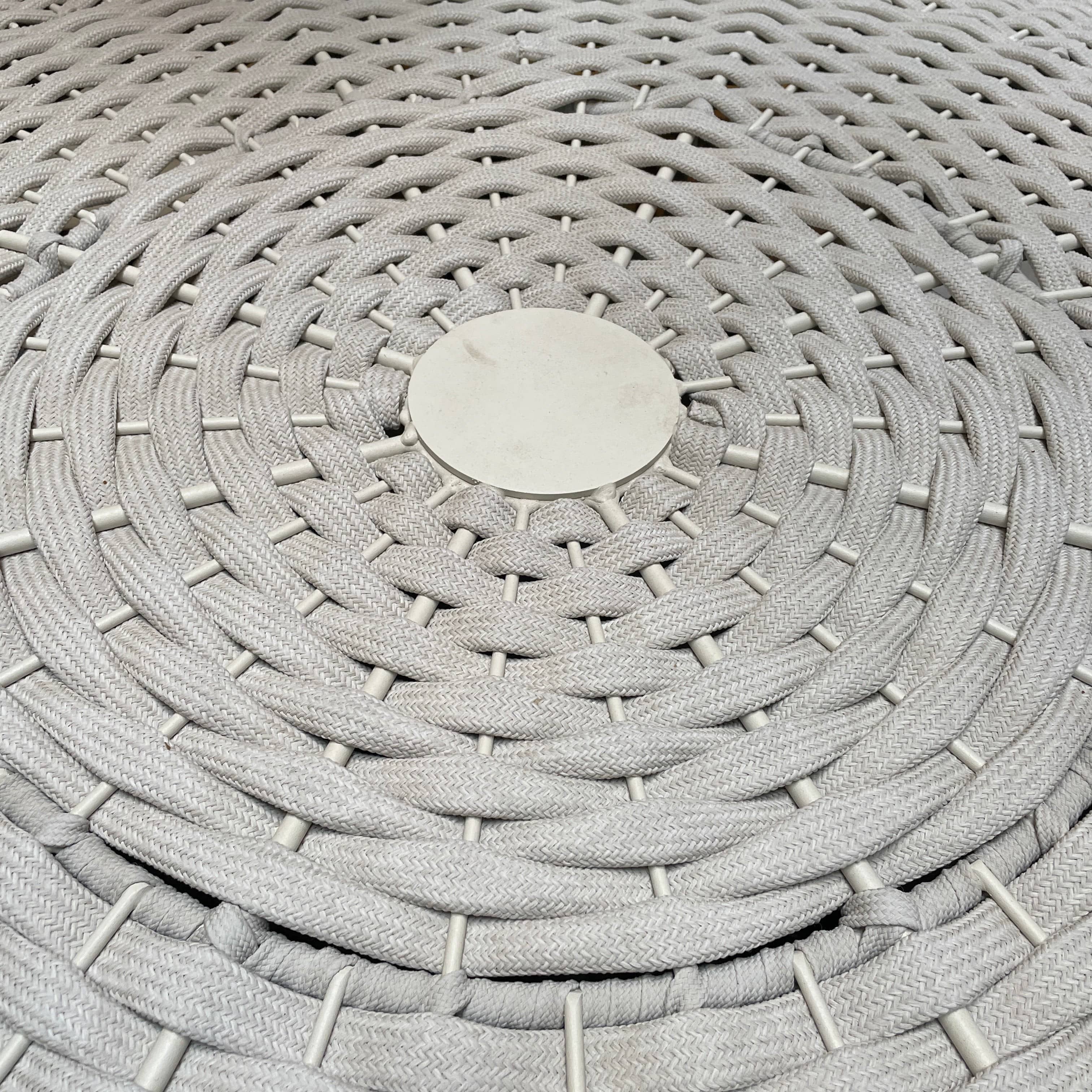 A Paola Lenti Mogambo Parasol on a white stand, designed by Paola Lenti.