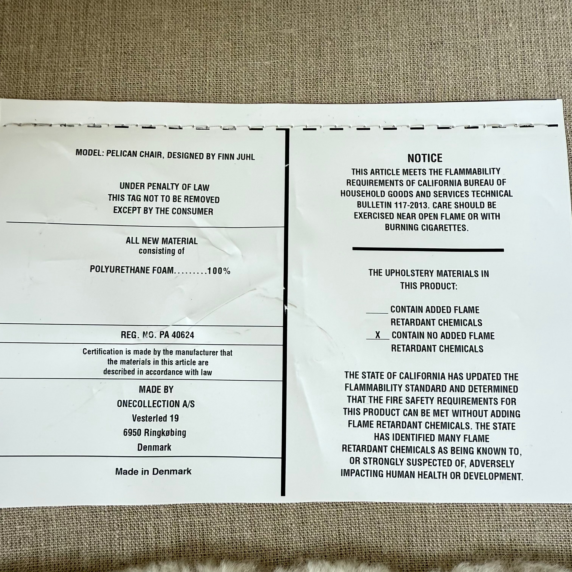 The House of Finn Juhl Finn Juhl Pelican Chair Sheepskin, with curved armrests and wooden legs, is displayed against a plain white background.