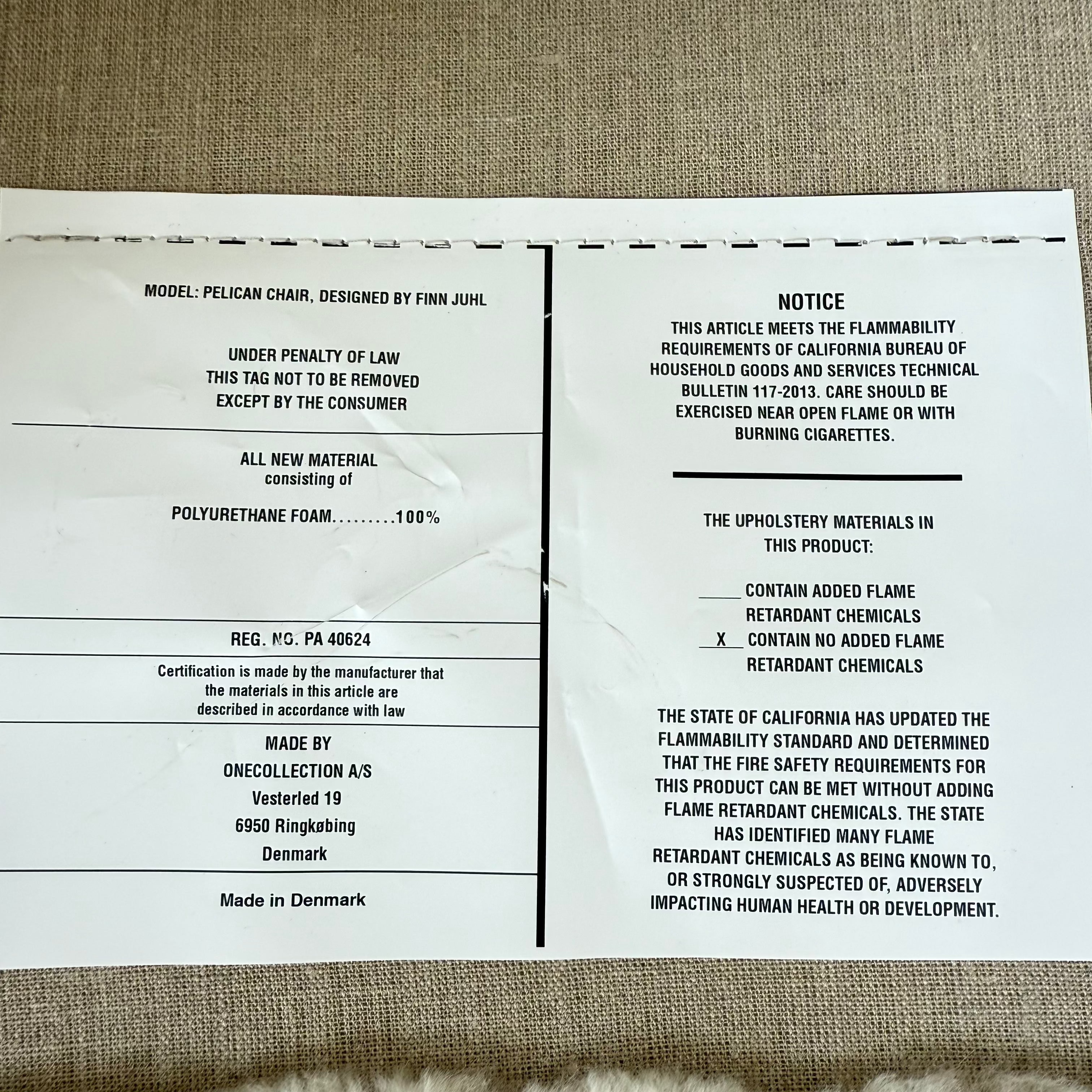 The House of Finn Juhl Finn Juhl Pelican Chair Sheepskin, with curved armrests and wooden legs, is displayed against a plain white background.