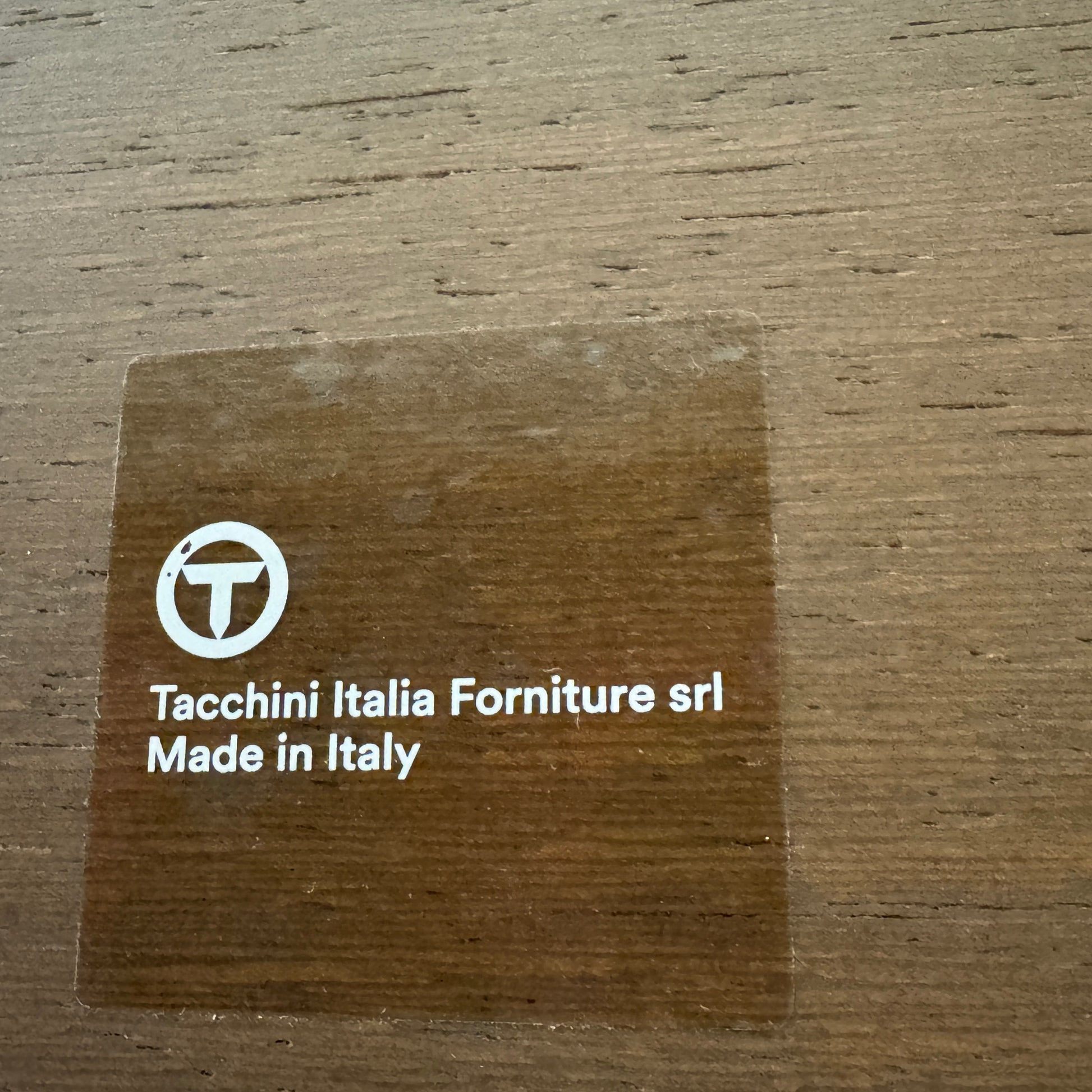 The Tacchini Five to Nine Day Bed by Tacchini features orange cylindrical cushions on a wooden frame—an ideal modern piece for an artist studio, shown here against a plain white background.