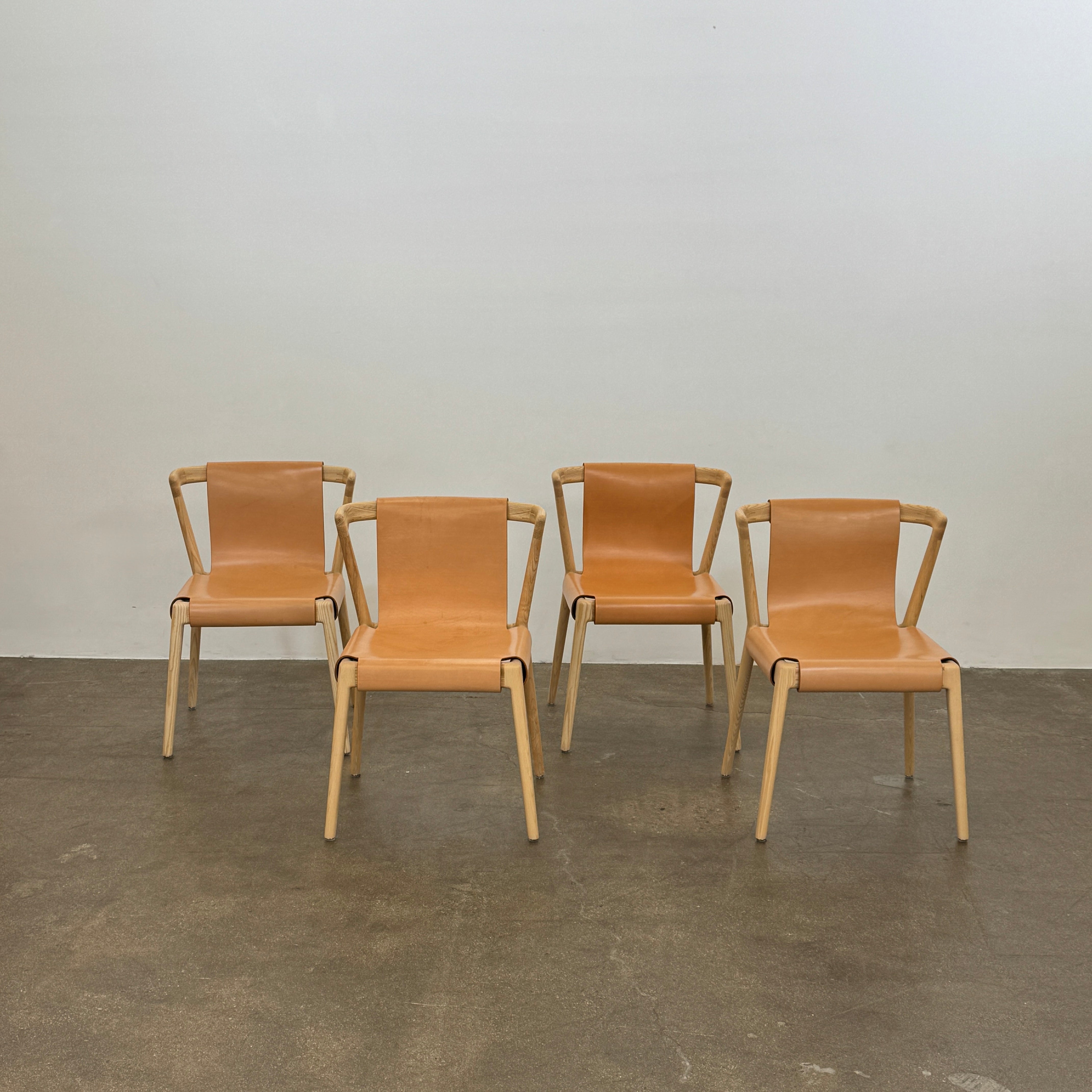 The Tom Feraday Pieman Dining Chair Set of 4 features Hydrowood timber frames and light brown leather seats and backs, offering a perfect blend of elegance and comfort. All four chairs are shown in two rows against a plain white background.