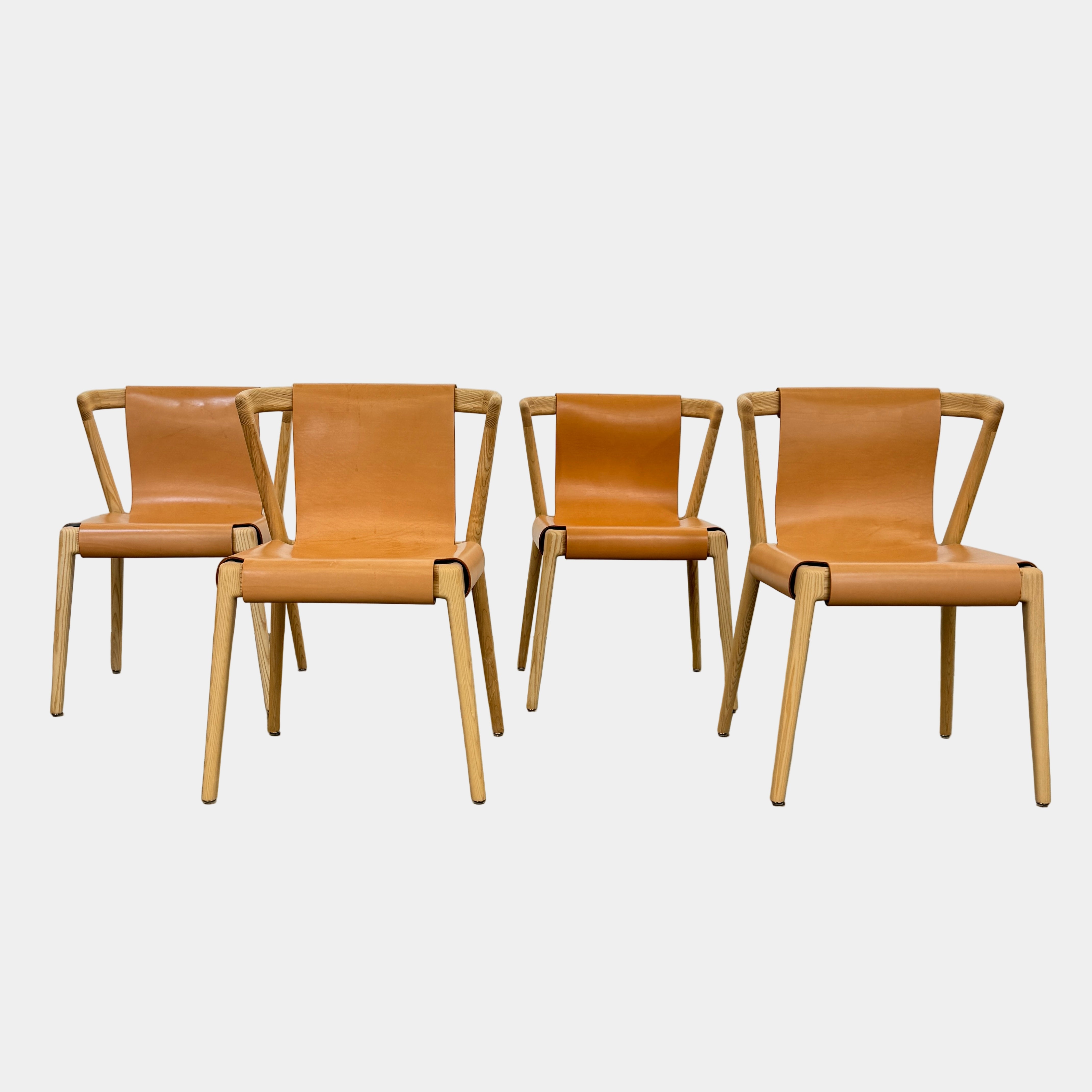 The Tom Feraday Pieman Dining Chair Set of 4 features Hydrowood timber frames and light brown leather seats and backs, offering a perfect blend of elegance and comfort. All four chairs are shown in two rows against a plain white background.