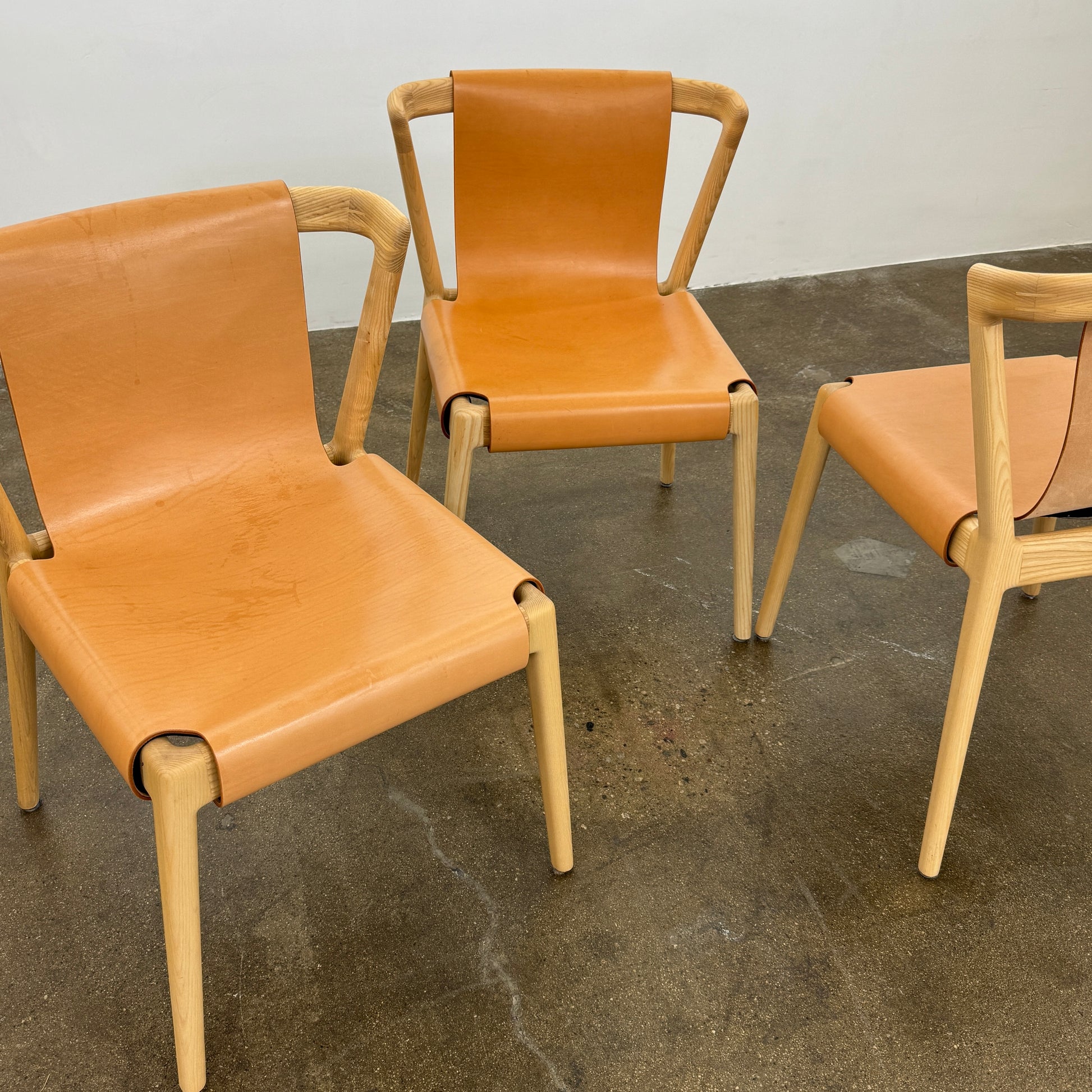 The Tom Feraday Pieman Dining Chair Set of 4 features Hydrowood timber frames and light brown leather seats and backs, offering a perfect blend of elegance and comfort. All four chairs are shown in two rows against a plain white background.