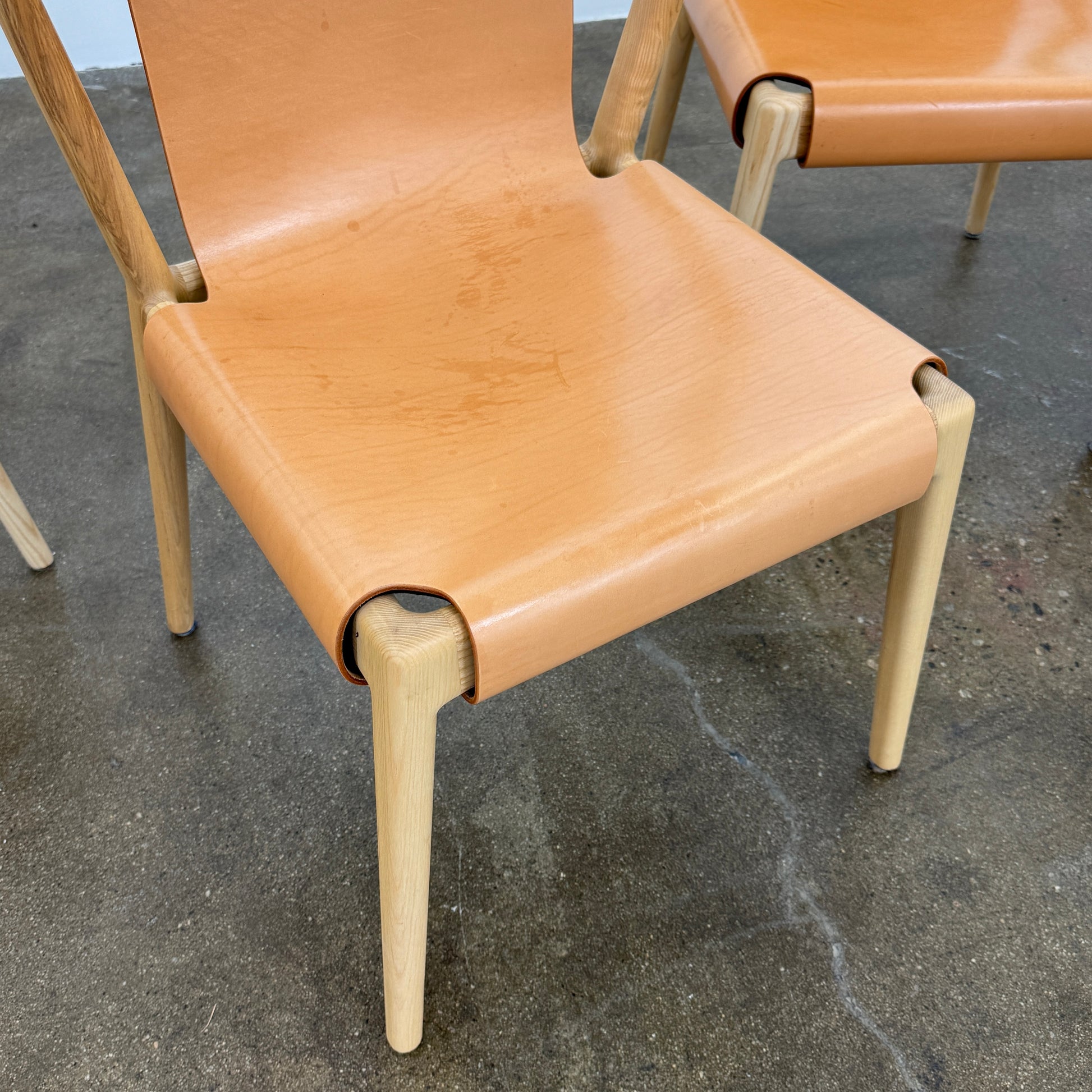 The Tom Feraday Pieman Dining Chair Set of 4 features Hydrowood timber frames and light brown leather seats and backs, offering a perfect blend of elegance and comfort. All four chairs are shown in two rows against a plain white background.