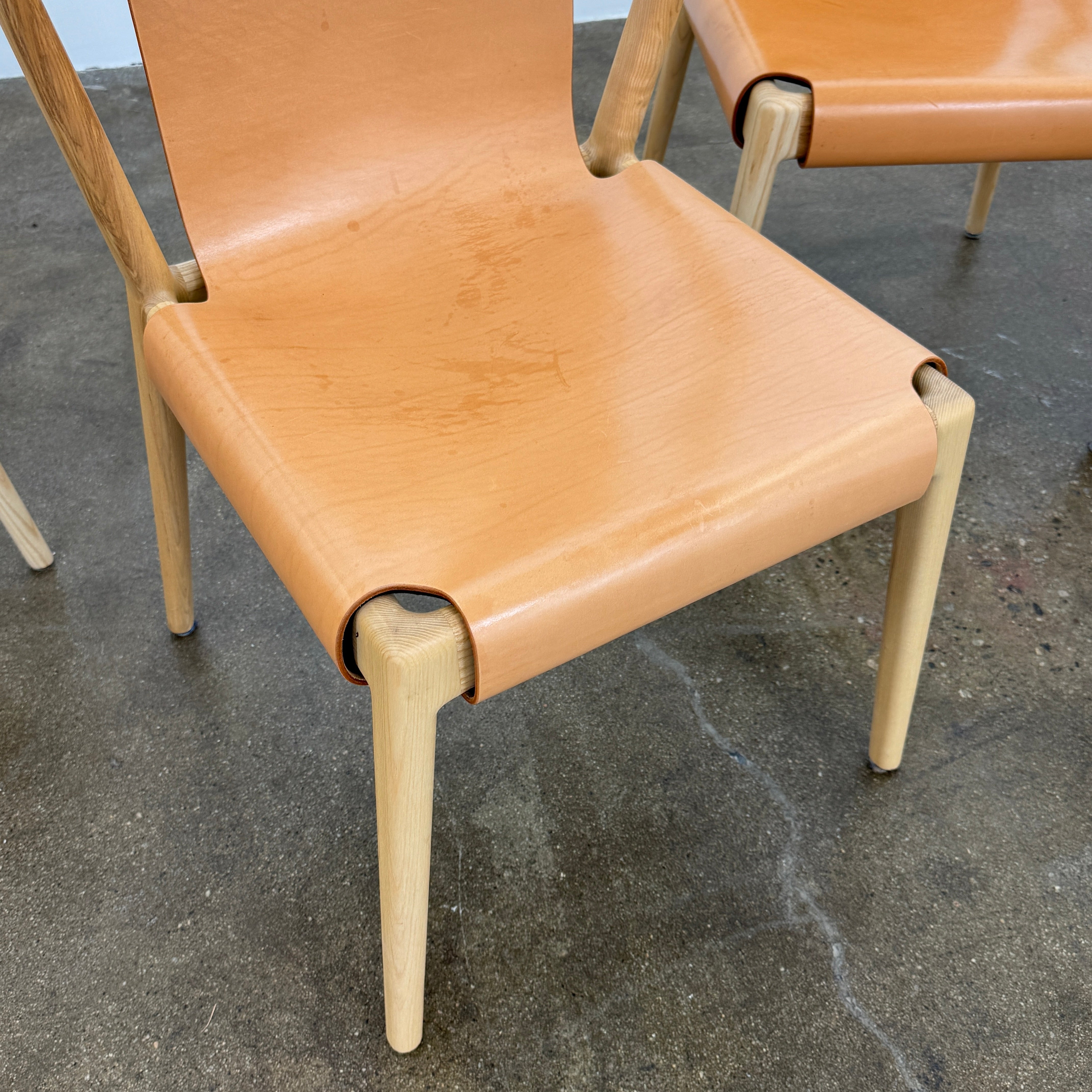 The Tom Feraday Pieman Dining Chair Set of 4 features Hydrowood timber frames and light brown leather seats and backs, offering a perfect blend of elegance and comfort. All four chairs are shown in two rows against a plain white background.