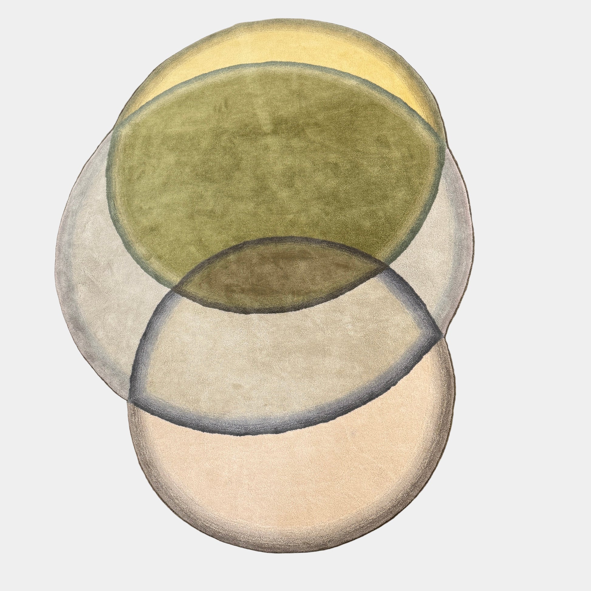 The Gan Crystal Rug by Gan, designed by Charlotte Lancelot, displays three overlapping circles in yellow, green, and beige set against a deep brown background.
