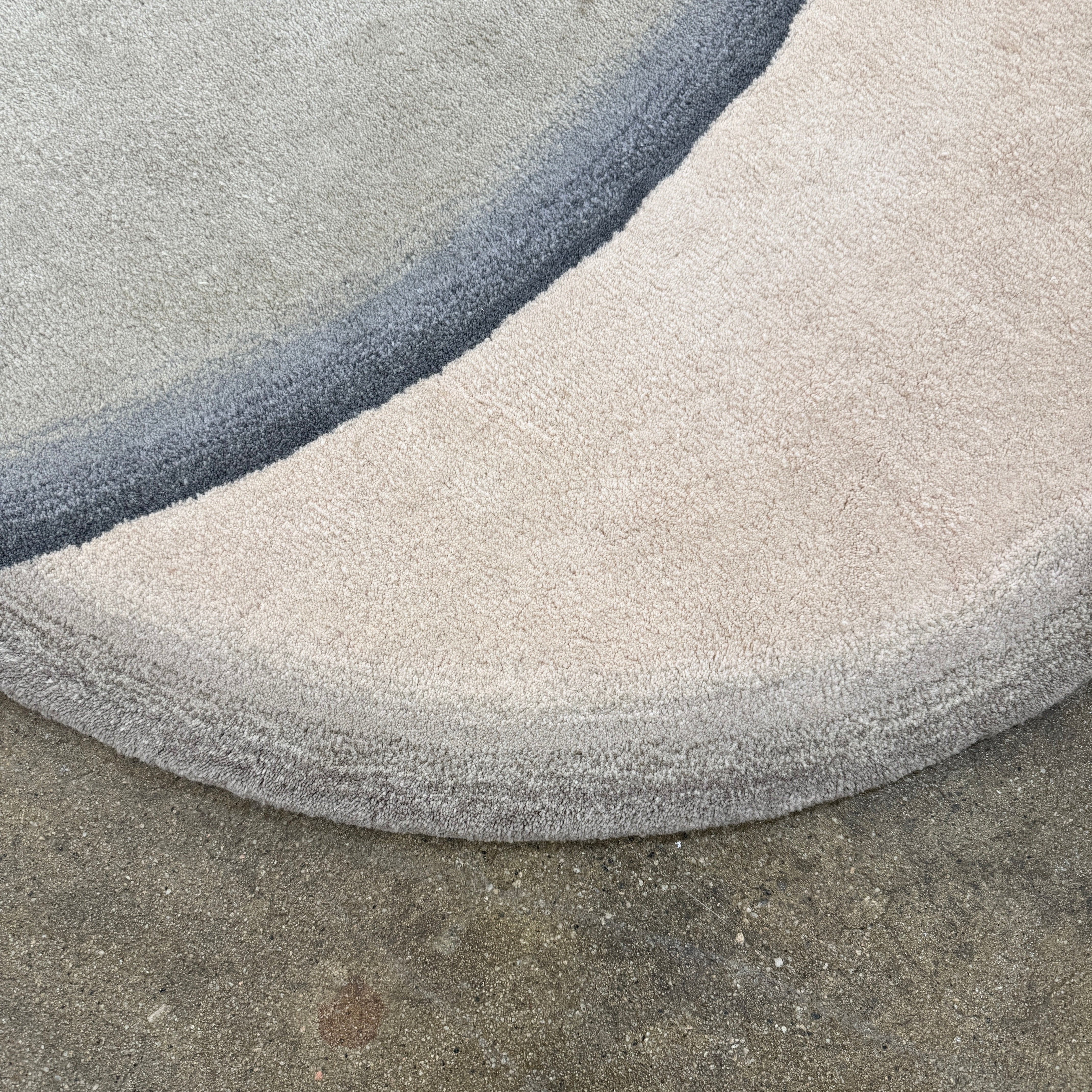 The Gan Crystal Rug by Gan, designed by Charlotte Lancelot, displays three overlapping circles in yellow, green, and beige set against a deep brown background.