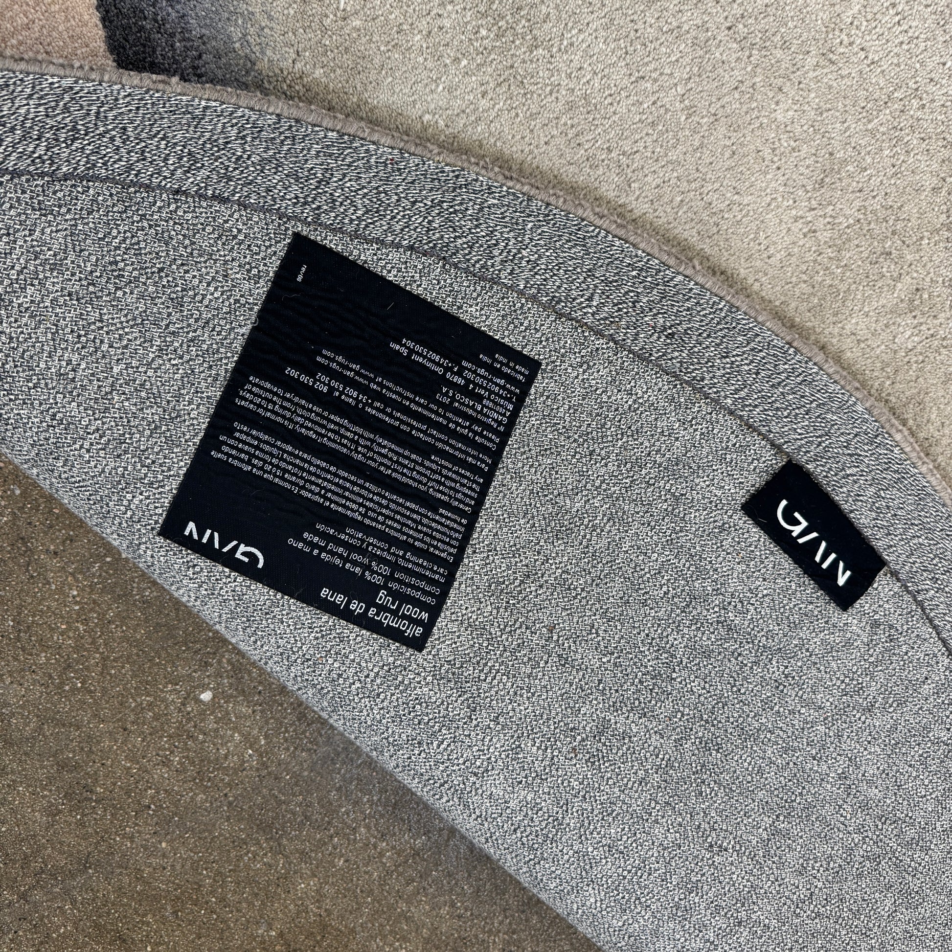 The Gan Crystal Rug by Gan, designed by Charlotte Lancelot, displays three overlapping circles in yellow, green, and beige set against a deep brown background.