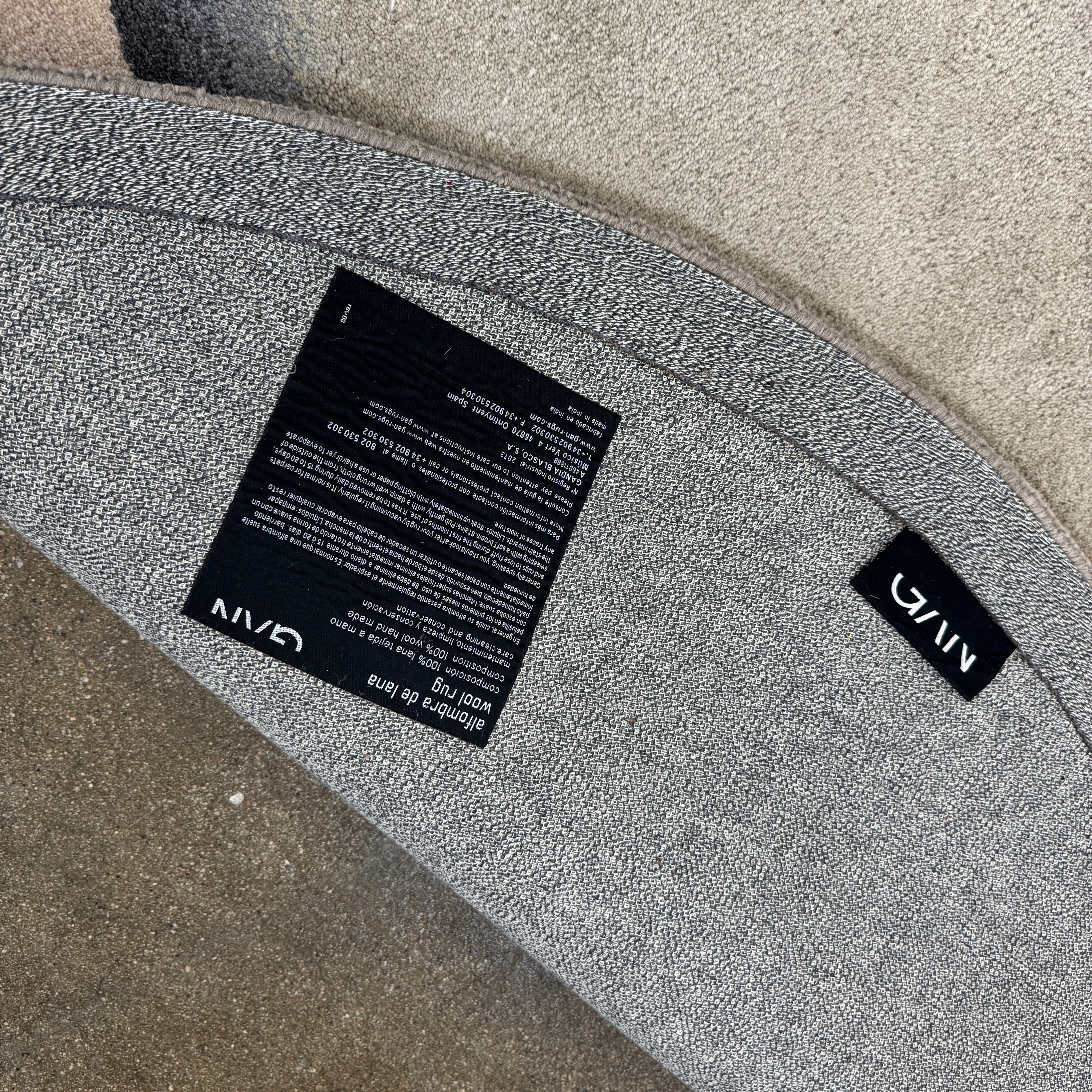 The Gan Crystal Rug by Gan, designed by Charlotte Lancelot, displays three overlapping circles in yellow, green, and beige set against a deep brown background.