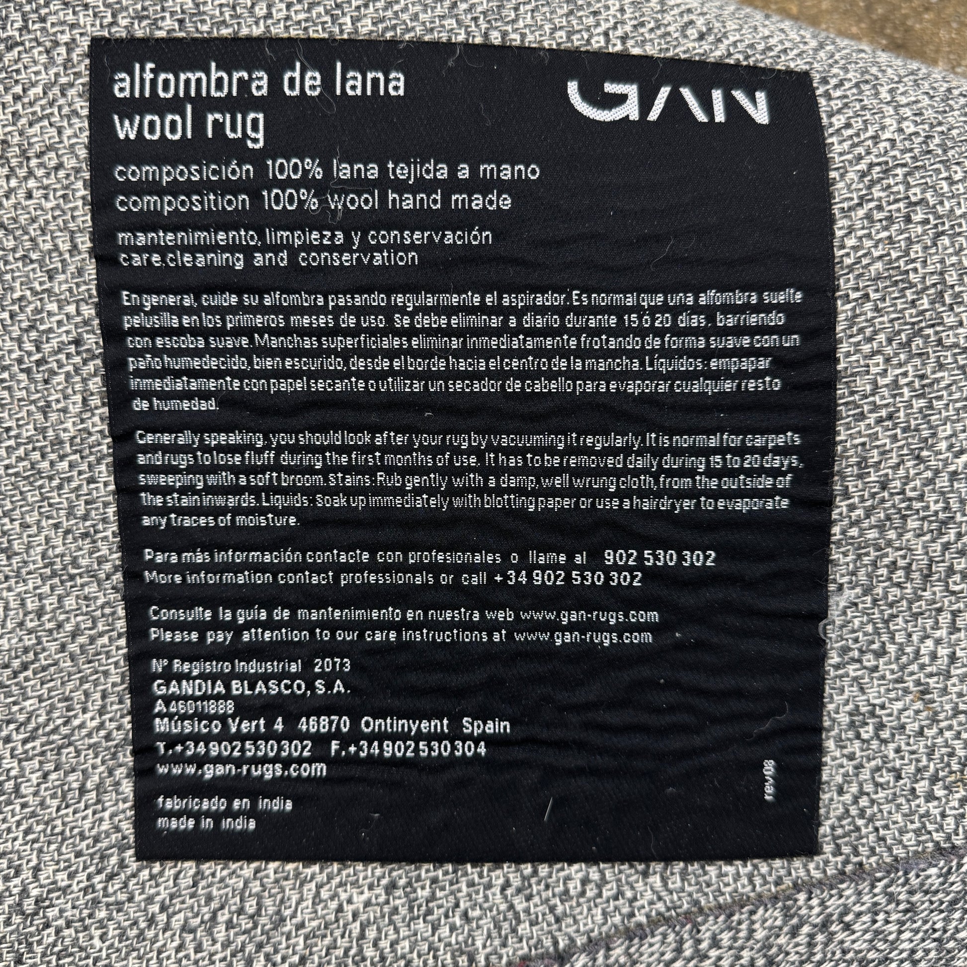 The Gan Crystal Rug by Gan, designed by Charlotte Lancelot, displays three overlapping circles in yellow, green, and beige set against a deep brown background.