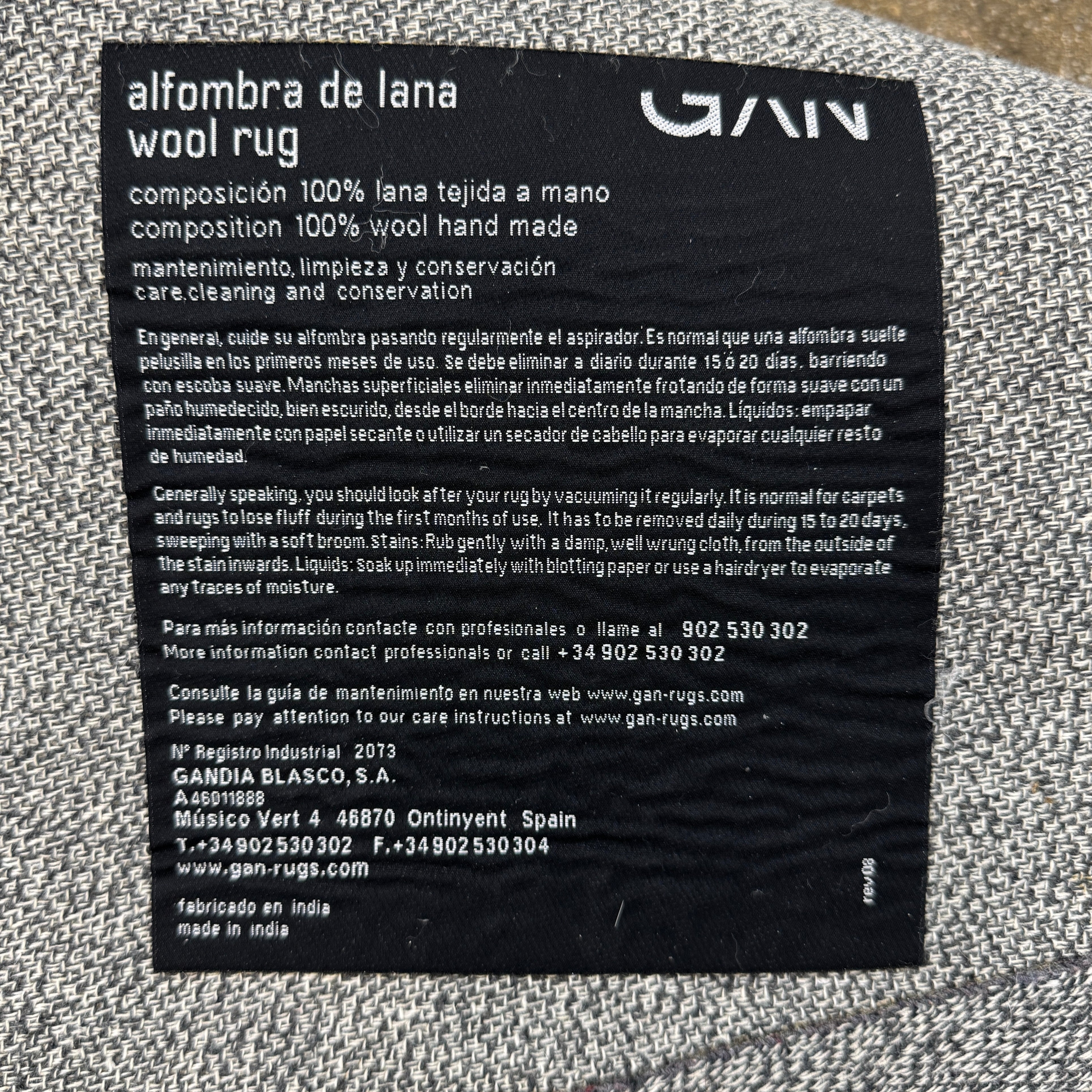 The Gan Crystal Rug by Gan, designed by Charlotte Lancelot, displays three overlapping circles in yellow, green, and beige set against a deep brown background.