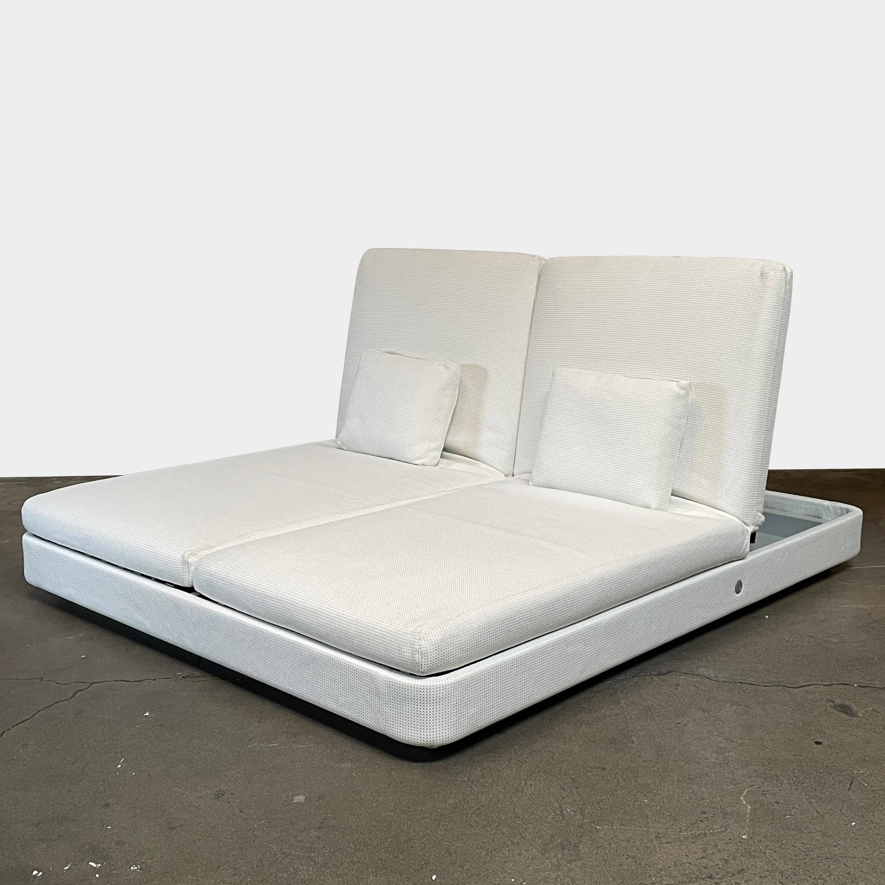 An adjustable white Paola Lenti Cove Double Sunbed by Paola Lenti features two separate reclining mattresses and matching pillows, perfect for outdoor lounging.