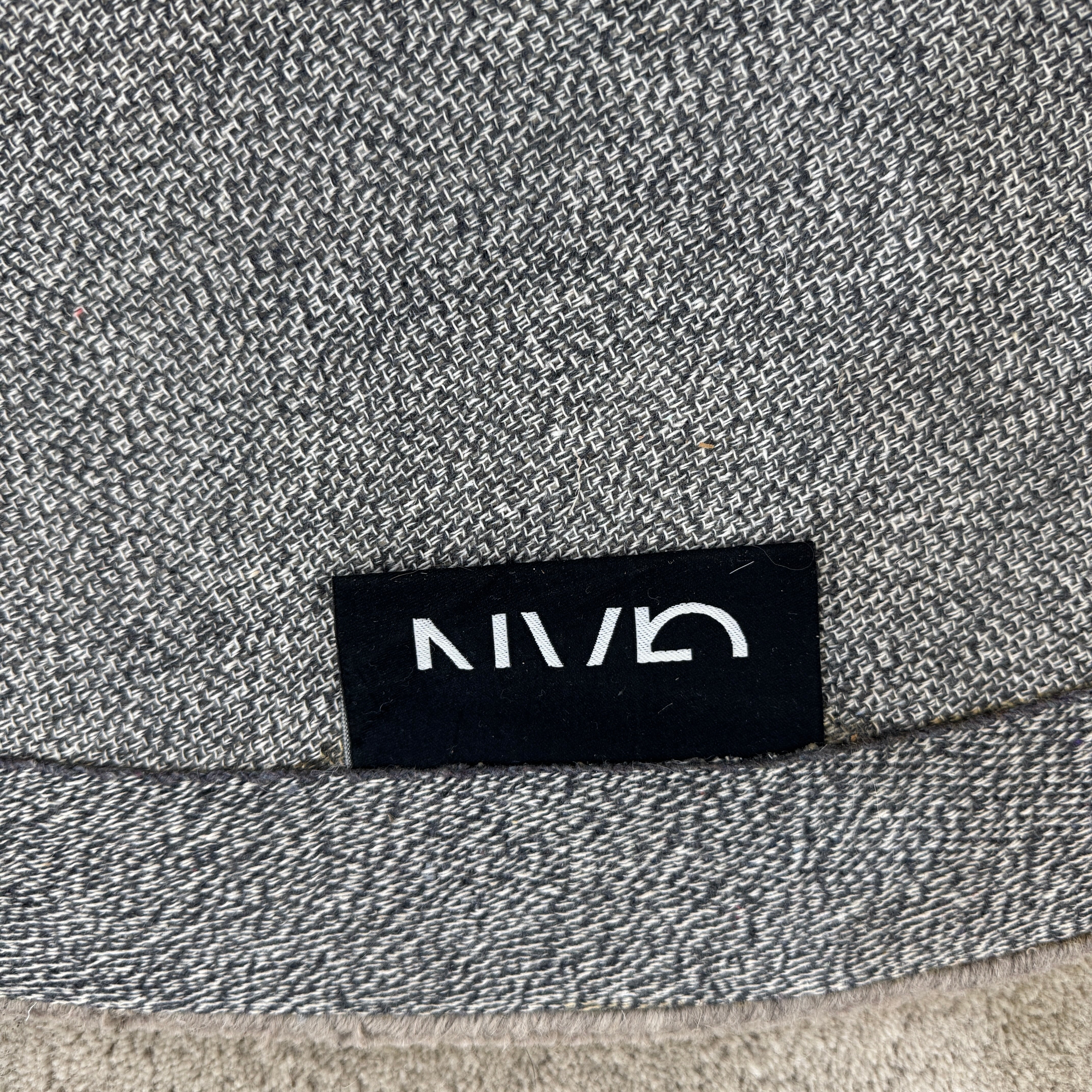 The Gan Crystal Rug by Gan, designed by Charlotte Lancelot, displays three overlapping circles in yellow, green, and beige set against a deep brown background.